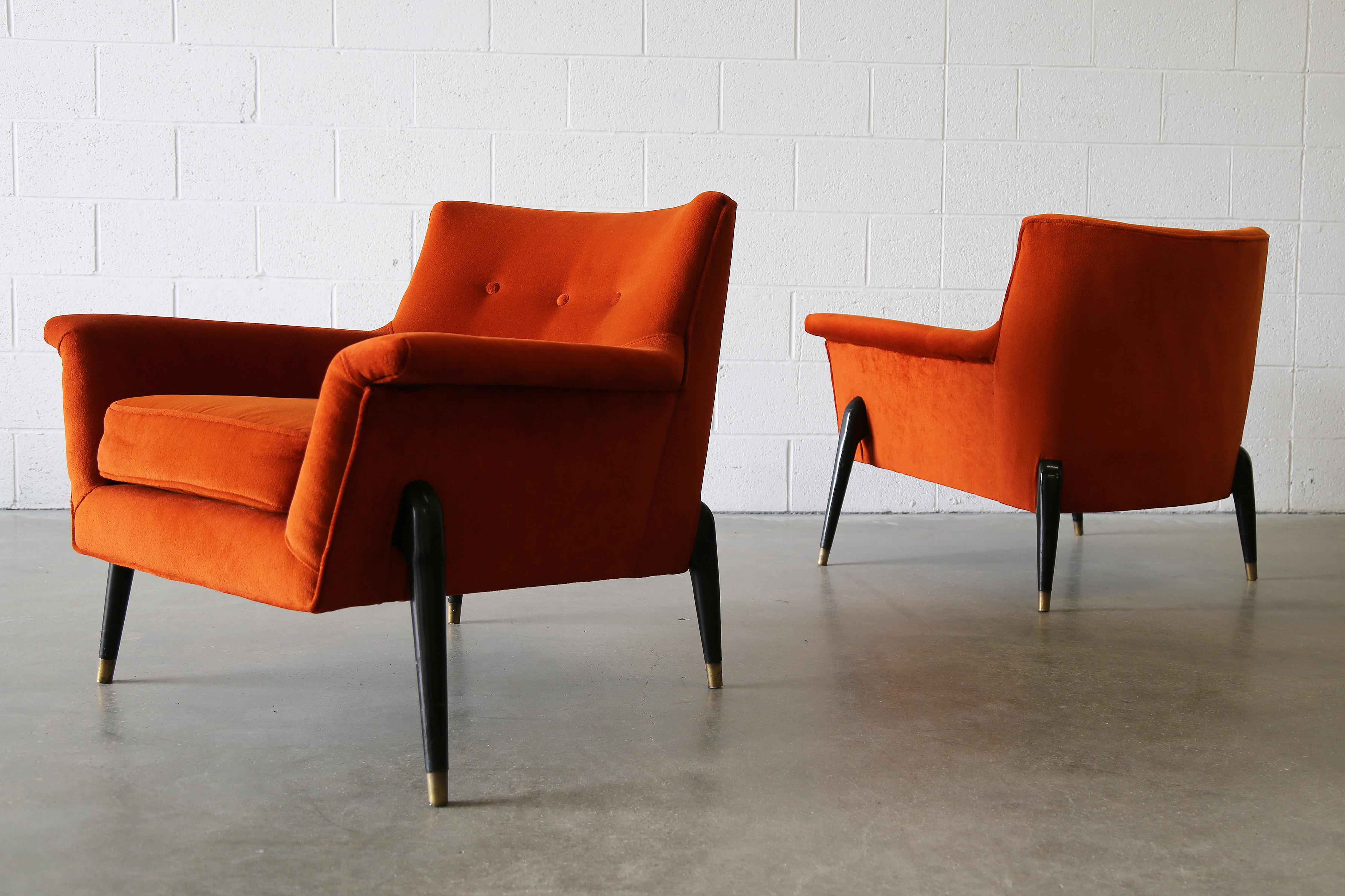 Paire de chaises longues à la manière d'Ice Parisi, vers les années 1960. Les caractéristiques du design comprennent des corps avec des bras évasés exagérés, suspendus par des pieds arqués, ébonisés et coiffés de laiton. Superbe design. Des chaises