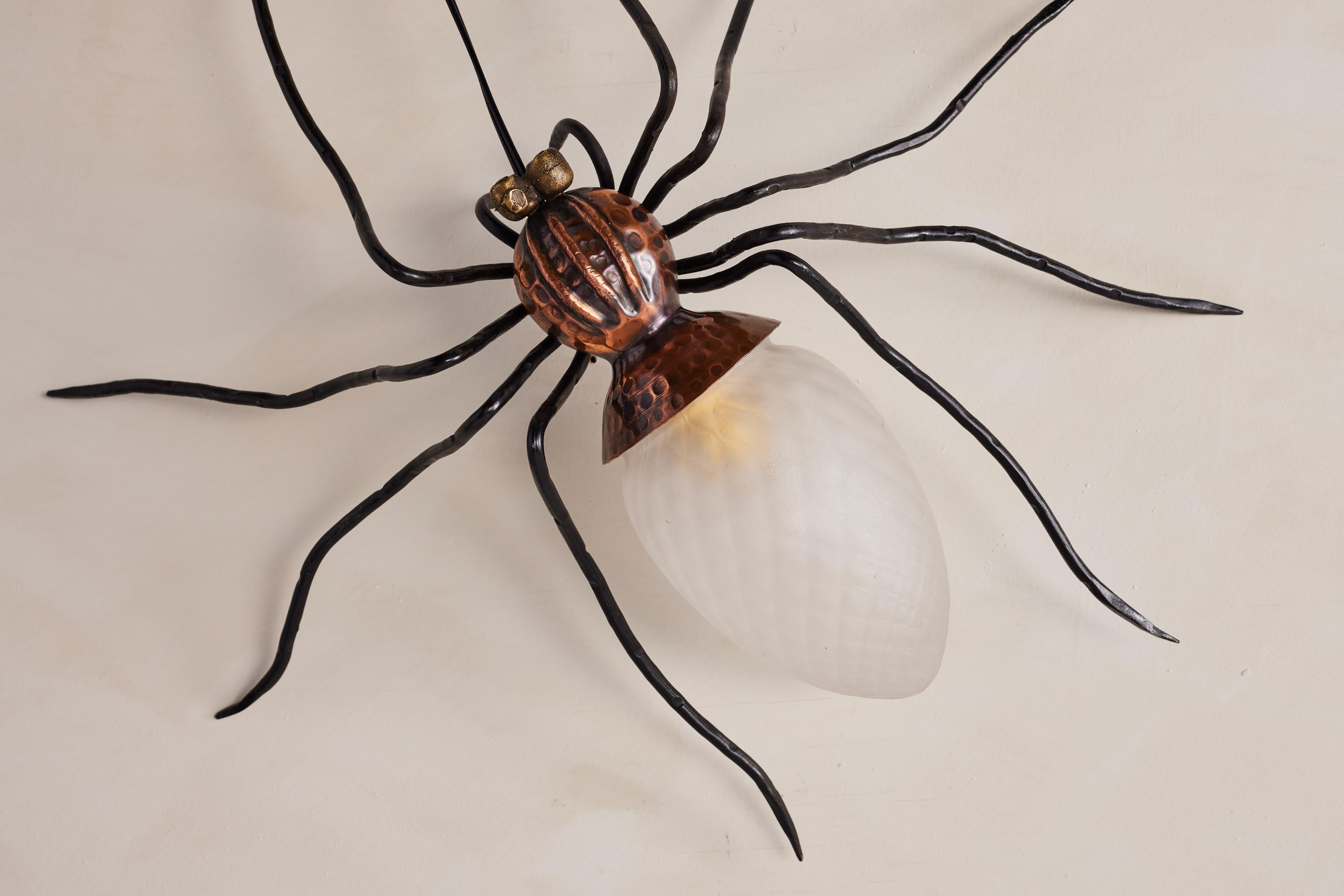 Unique copper and metal spider sconces handmade in Italy. 
Hammered copper body with black head and slender long legs. 
Original Murano glass shade as his body. 

Italy 1960s