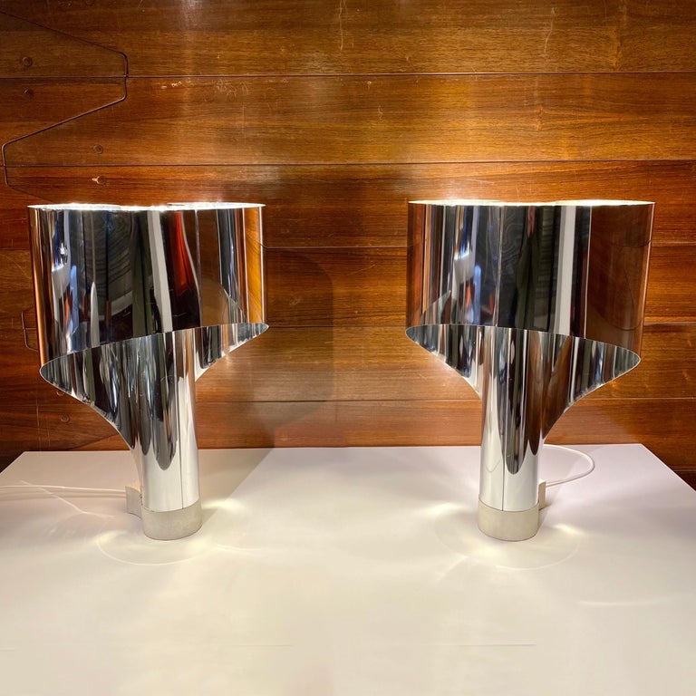 Pair of lamps in stainless steel and white laquered aluminium base .Model Spinnaker created in 1968 by Constantino Corsini and Girgio Wiskemann for Stilnovo.Two lighting system,double light bulb inside and a light with neon at the back. The two