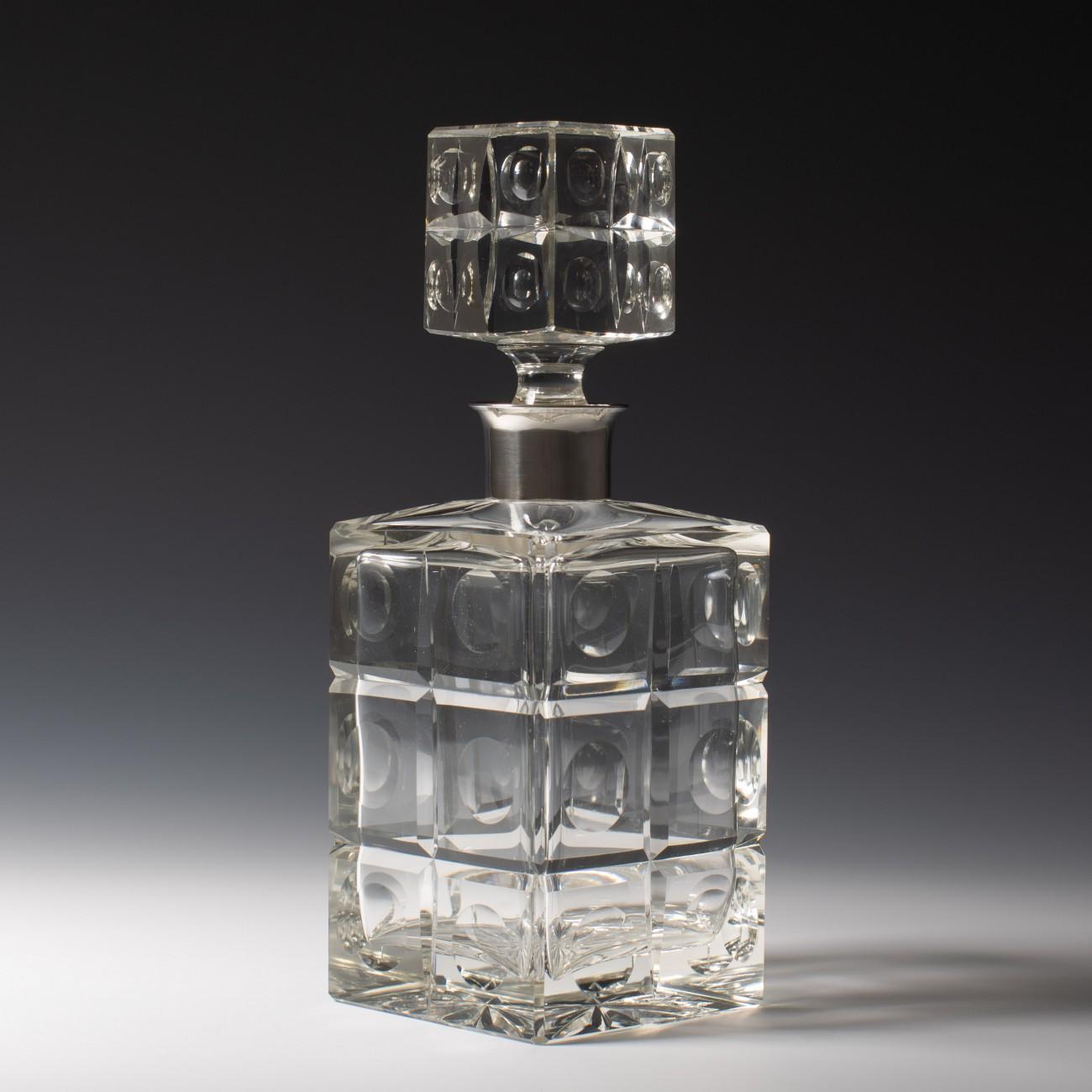 Stylishly crafted in heavy cut glass with sterling silver collars and cut glass stoppers. One hallmarked London, 1974, the other hallmarked London, 1977. With maker's marks for Israel Freeman & Son, and Garrard and Co.

Dimensions: 25 cm/9¾ inches