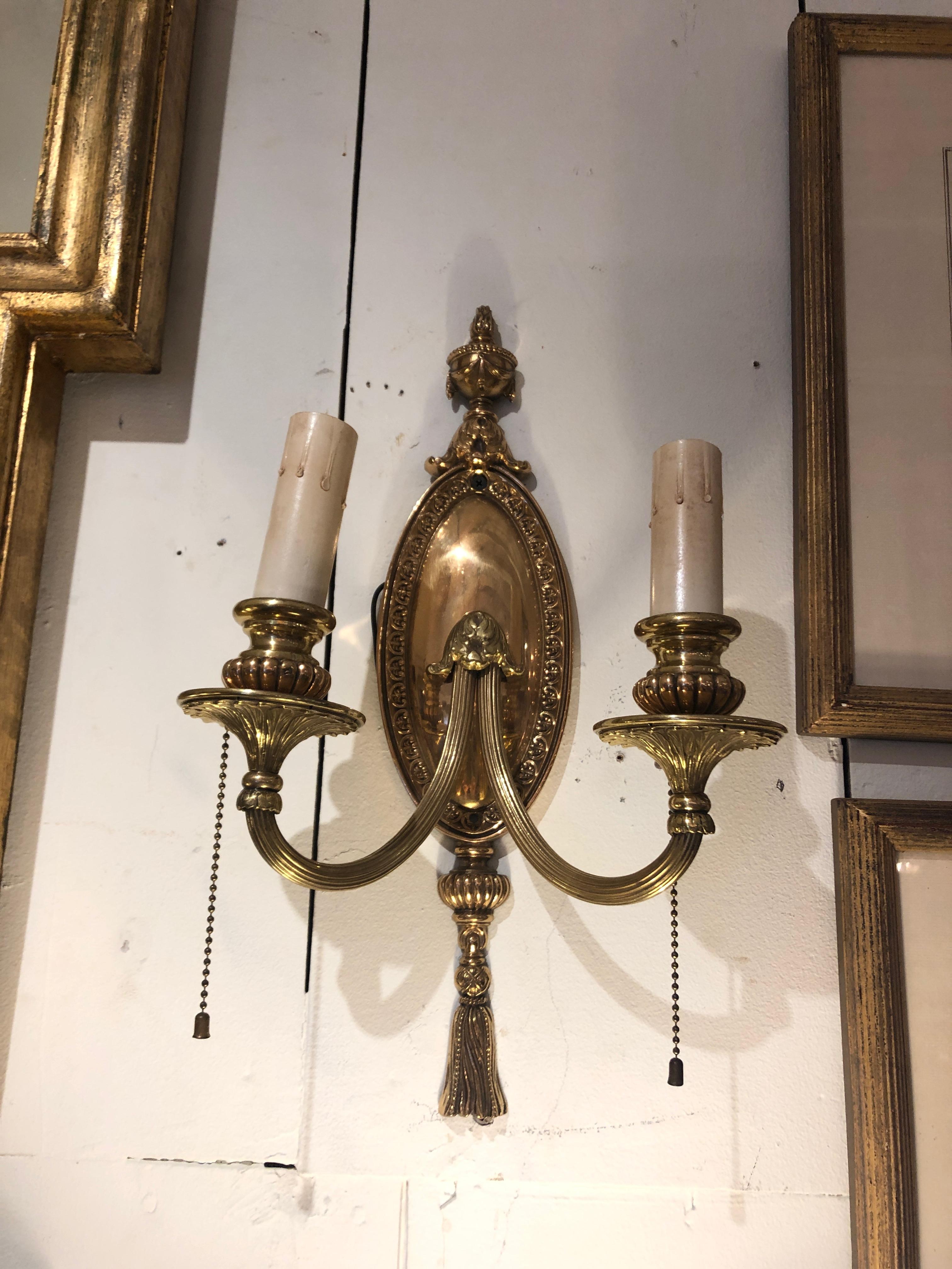 Absolutely sublime top drawer bronze electried antique wall sconces having 2 lights each, and marvelous decoration including urn at the top, tassel at the bottom, acanthus leaves and more.