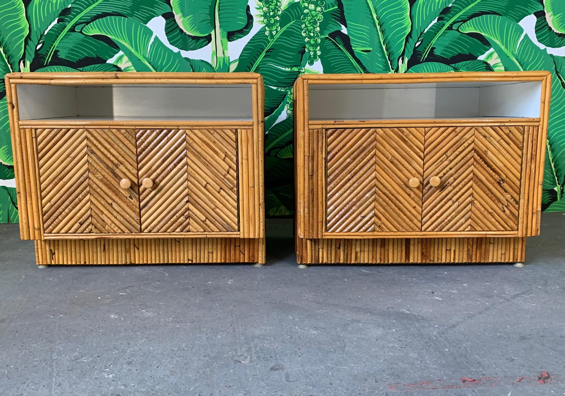 Pair of vintage nightstands fully wrapped in split reed rattan featuring a chevron design on door fronts. Very good condition with only very minor imperfections consistent with age.