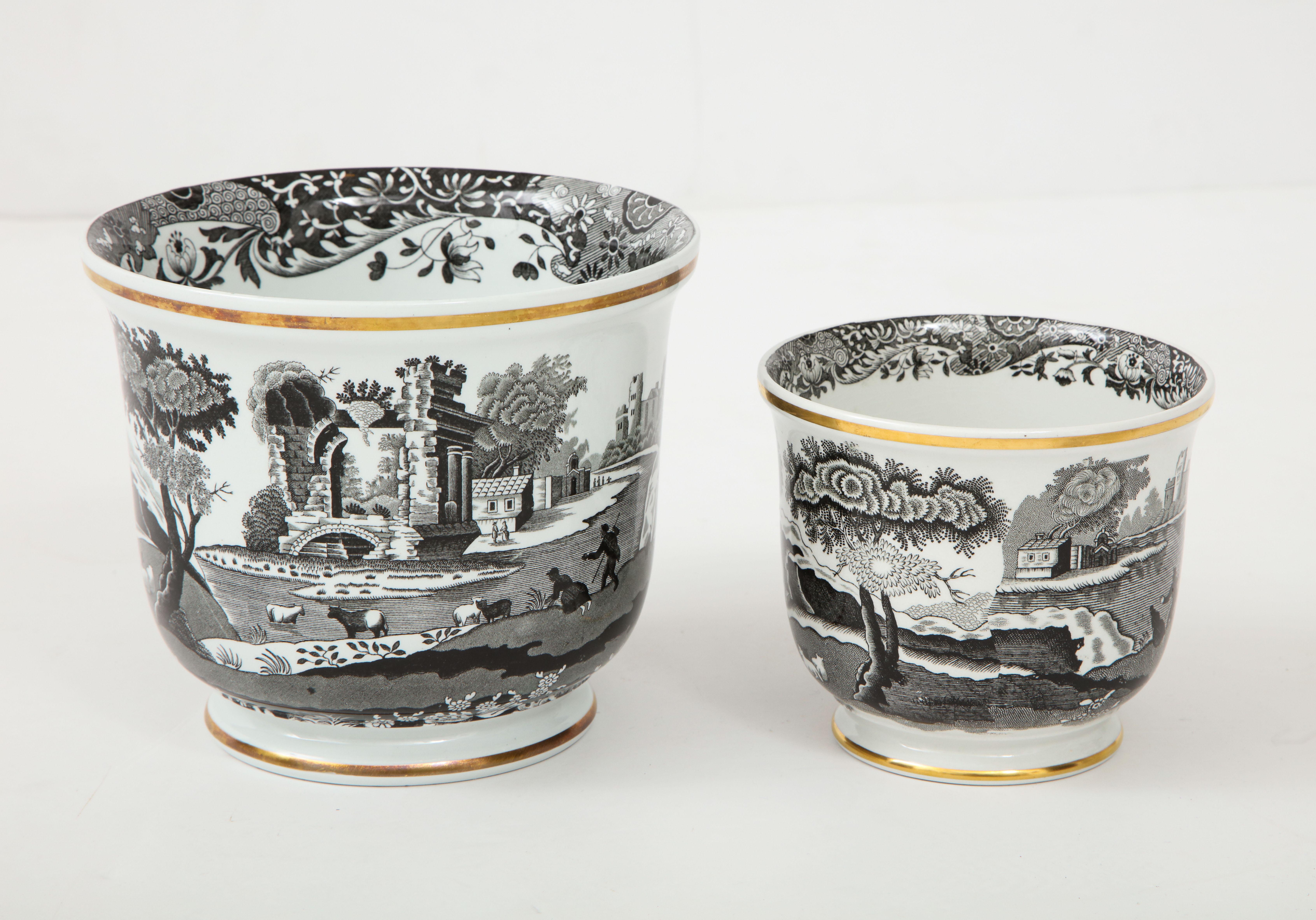 Pair of black and white transfer wear cach potrs depicting scenes of the English countryside, each trimmed with a gold stripe. Stamped on bottom, sold as a pair

Larger vessel measures 5.75
