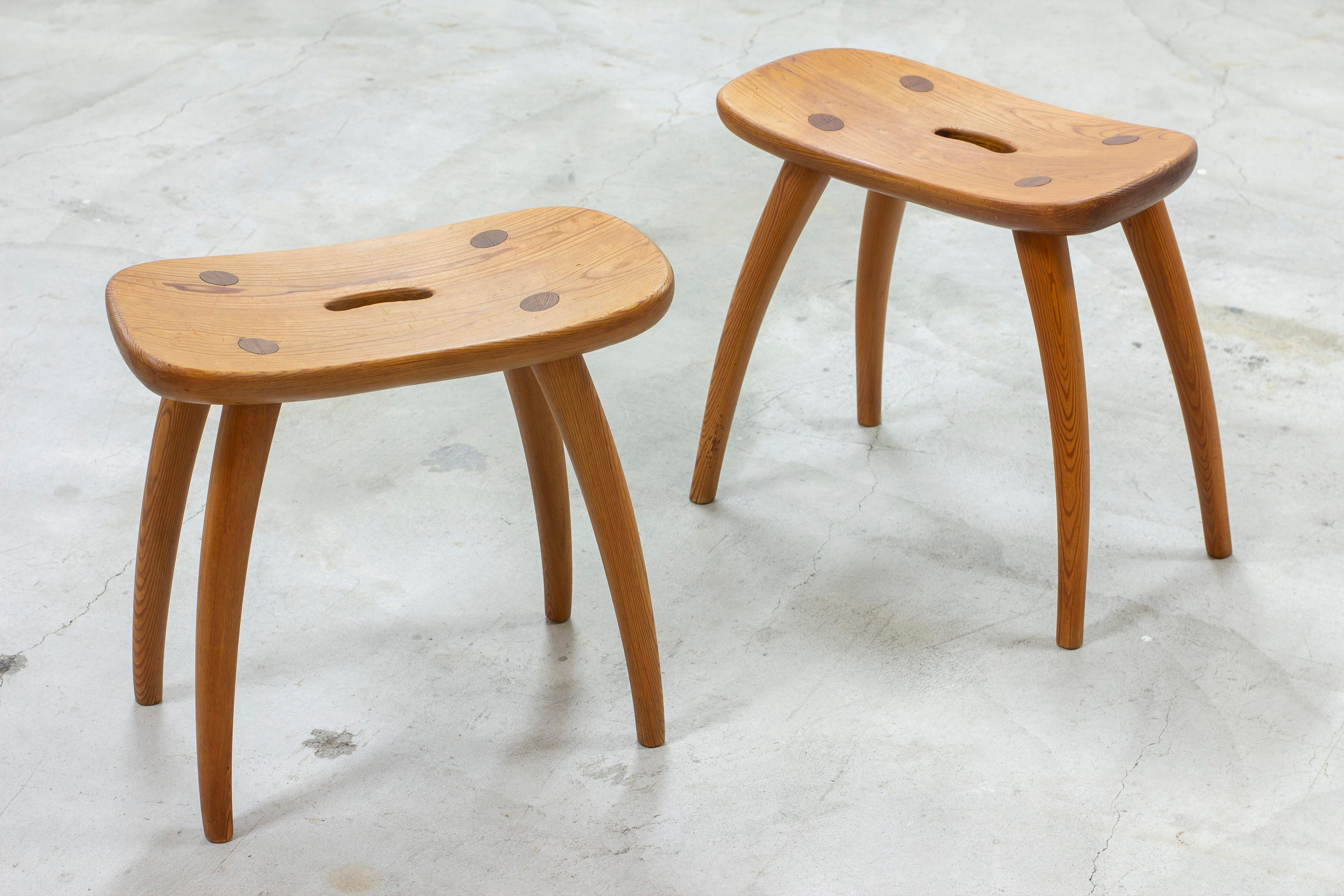 Pair of sportstuge stools designed by Torsten Claesson. Produced by Steneby Hemslöjd during the late 1930 or 1940s. Made from solid pine with beautifully darkened patina. Curved seat and legs with visible joinery in the seat. Good vintage condition