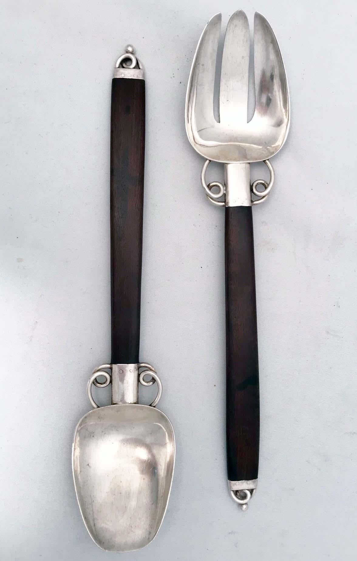 Spratling made numerous stylish items in his day and these salad servers are among that production. The deep brown and slightly redish wood contrasts subtilty with the sterling silver.
