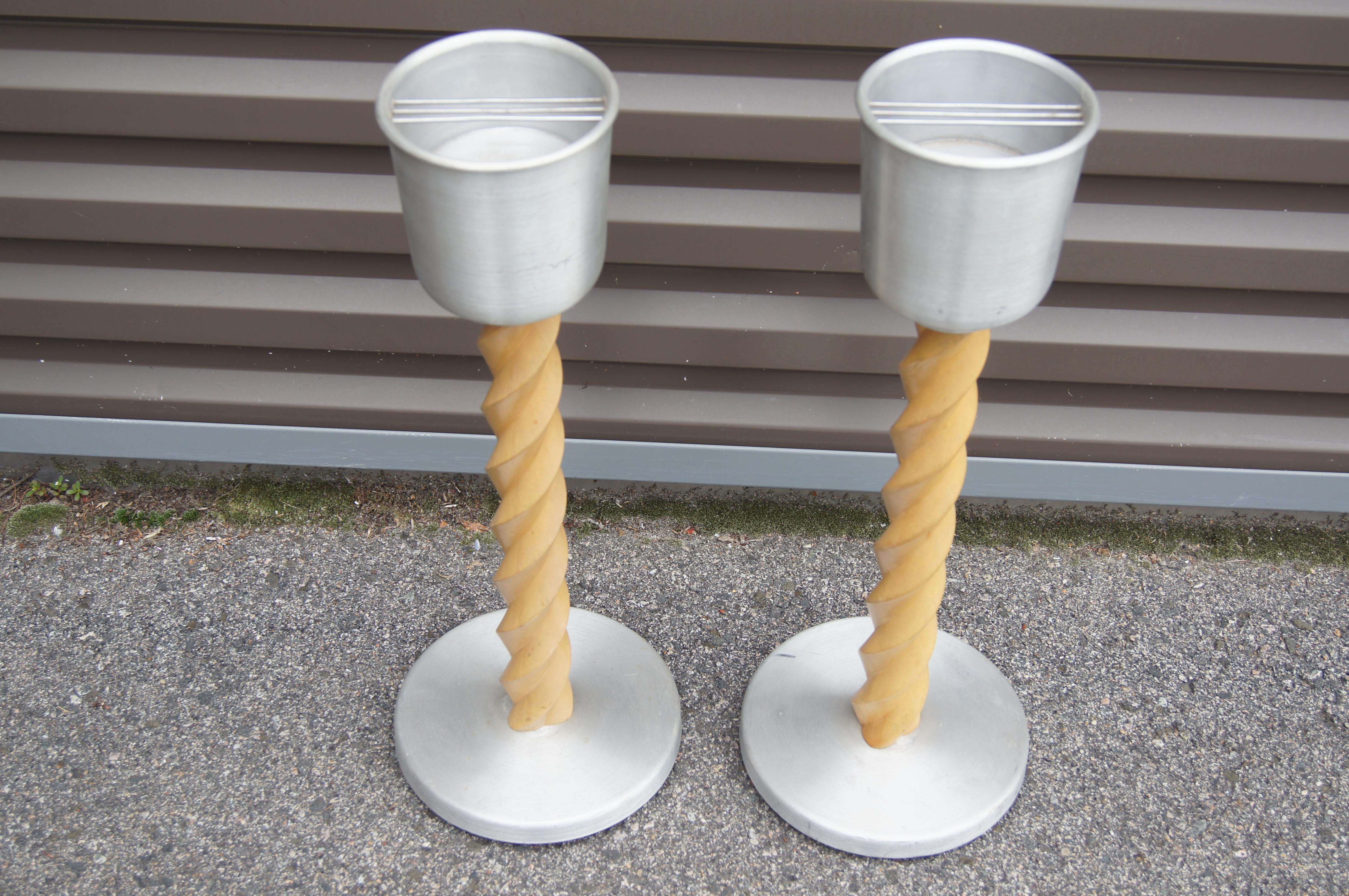This pair of 1930s standing ashtrays are attributed to Russel Wright. Each Machine Age smoking stand features a turned oak support between a spun aluminum base and a deep receptacle for cigarette ash.