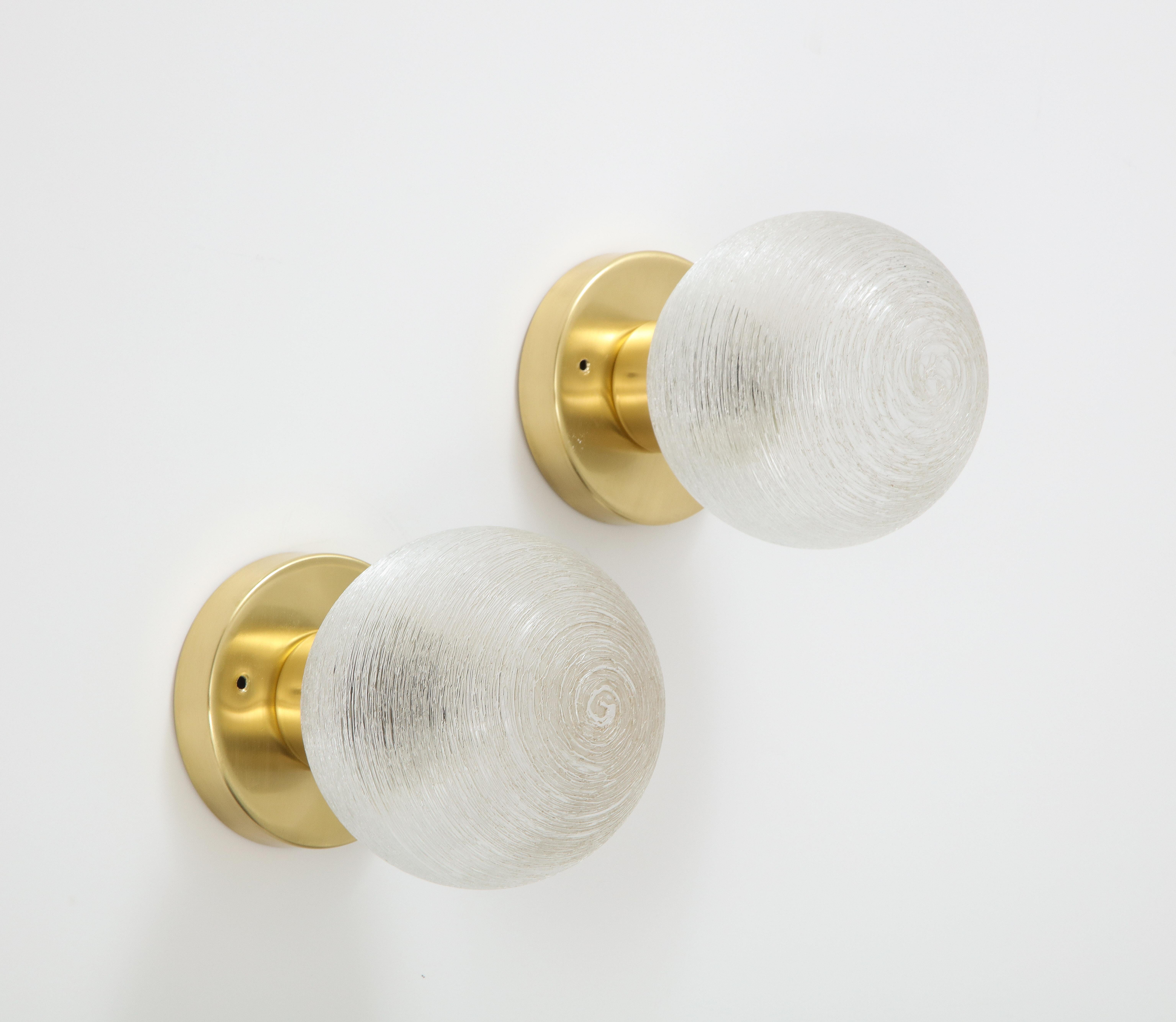 Pair of spun glass globe sconces by Doria.
The globes are mounted on polished brass bases that have been Newly rewired for the US and take a single candelabra light bulb with a 40 Watt Maximum.