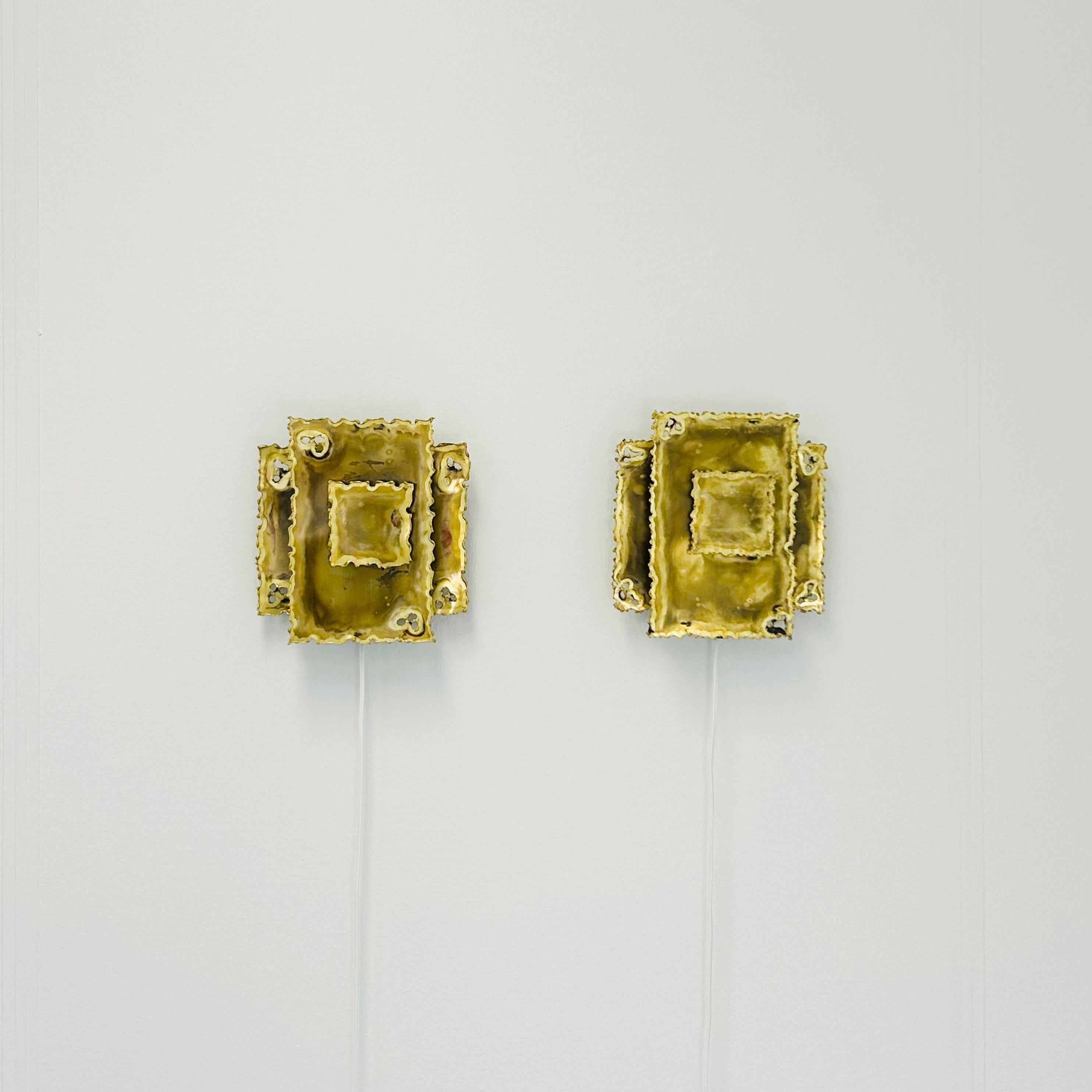 A fine pair of wall lamps designed by the legendary Svend Aage Holm Sørensen in the 1960s and produced by his company Holm Sørensen & Co. in Denmark. These lamps is the classic style no. 5202, featuring multi-layered square flame-cut brass plates