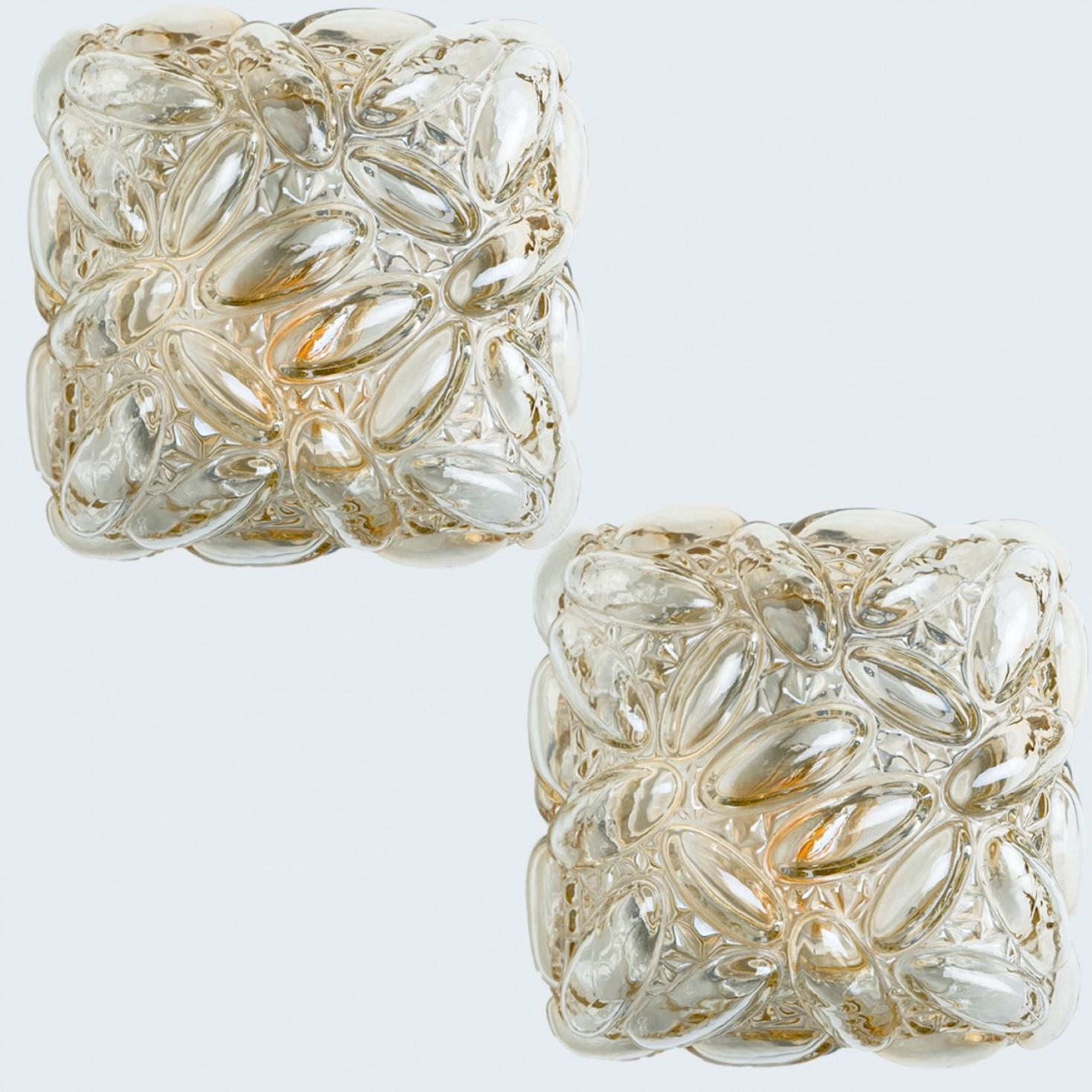 1 of the 2 clear bubble glass wall light designed in the style of Helena Tynell around 1960-1970 in Europe, Germany. The rich textured bubbled glass gives a wonderful glow. The square-shaped glass is mounted on a gold colored metal back plate.

Can