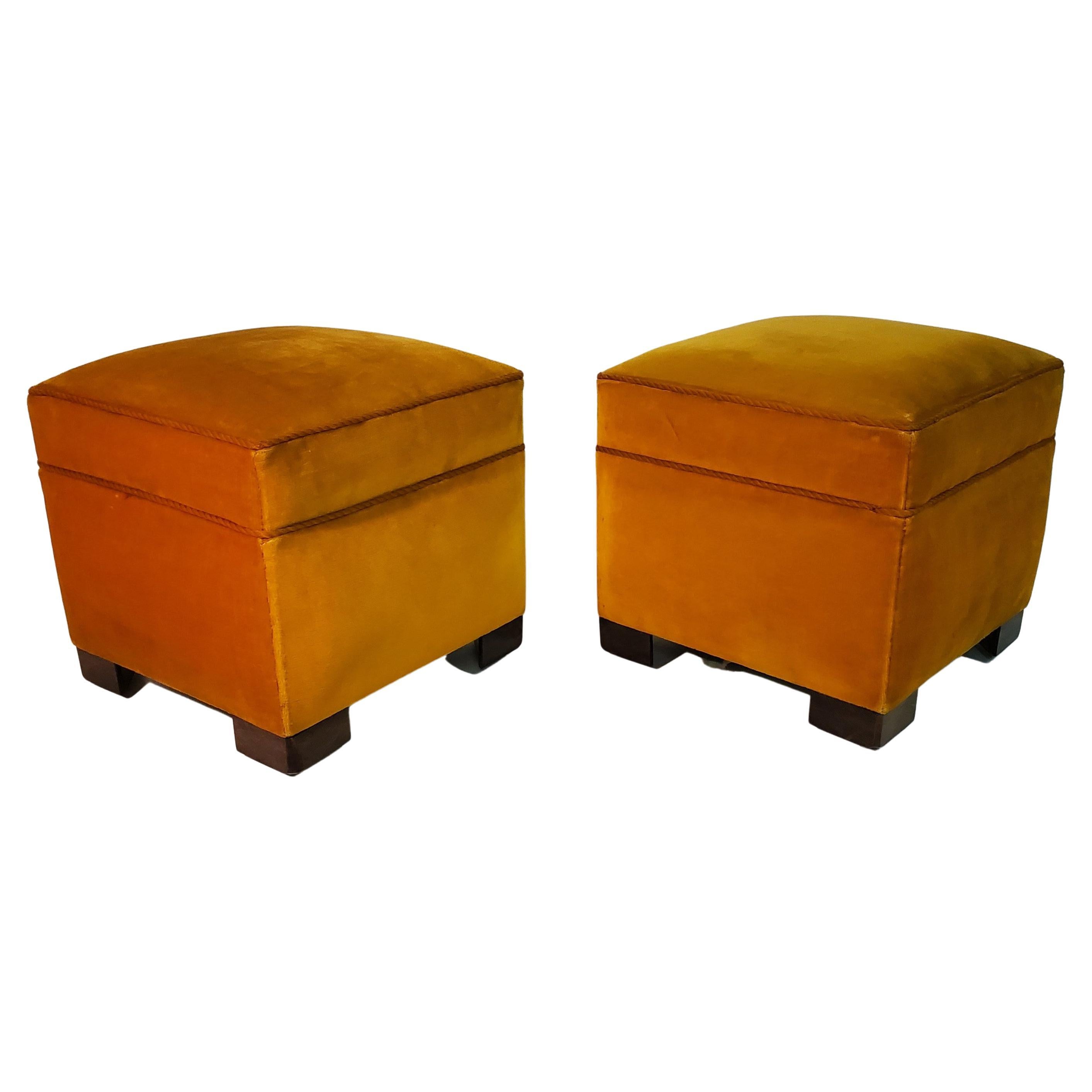 A pair of vintage square yellow upholstered ottomans with cubist wood feet.
 The poufs are covered in the original bright yellow velvet fabric that adds a pop of color to the space. They have a square shape, which gives them a modern and geometric