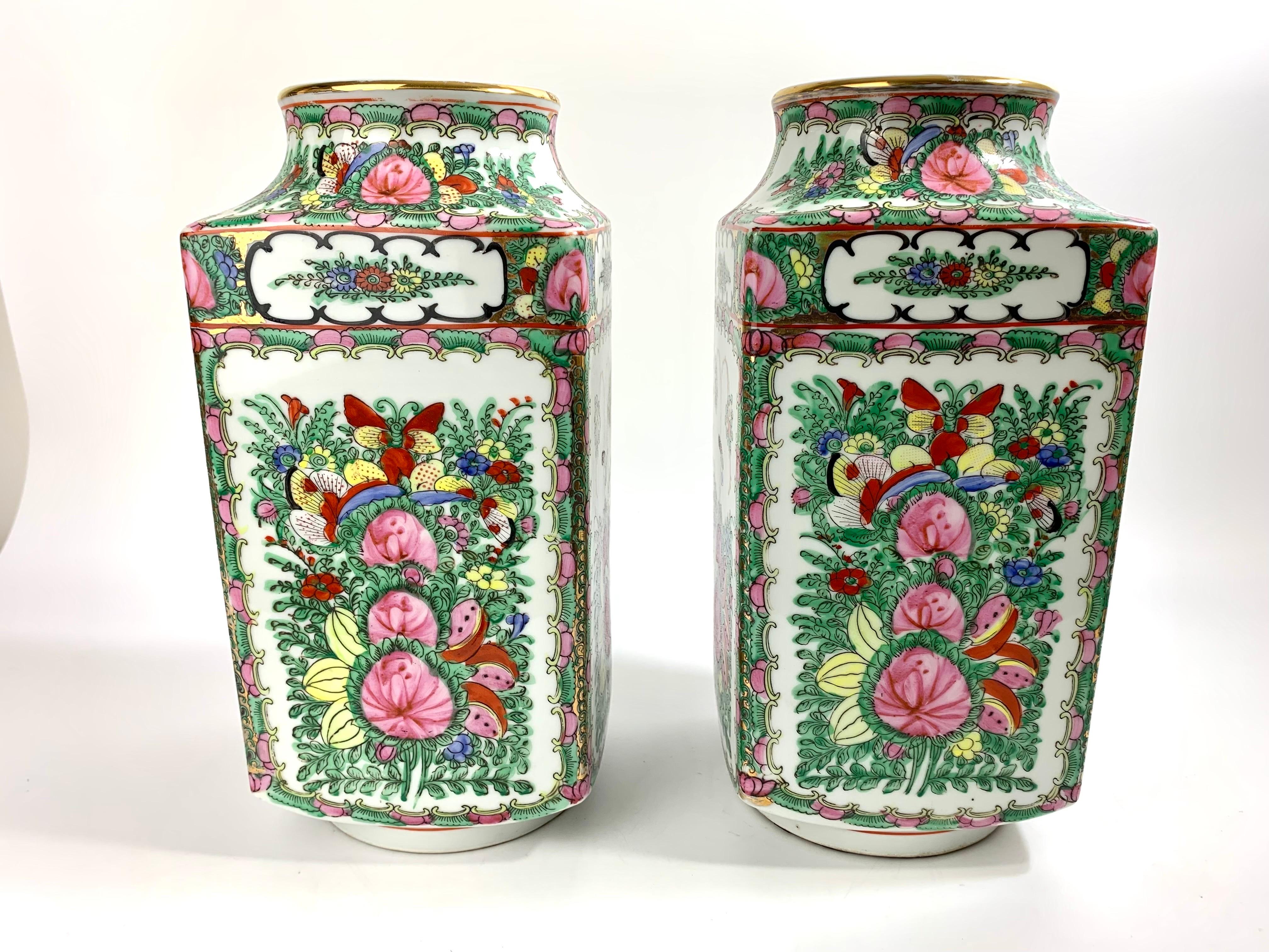Beautiful pair of large hand painted Rose Canton vases.  Floral and insect designs.  Previously used as lamp bases they both have holes drilled into the bottom.  They can also function as vases if you drop a glass vase inside.  Marked as porcelain