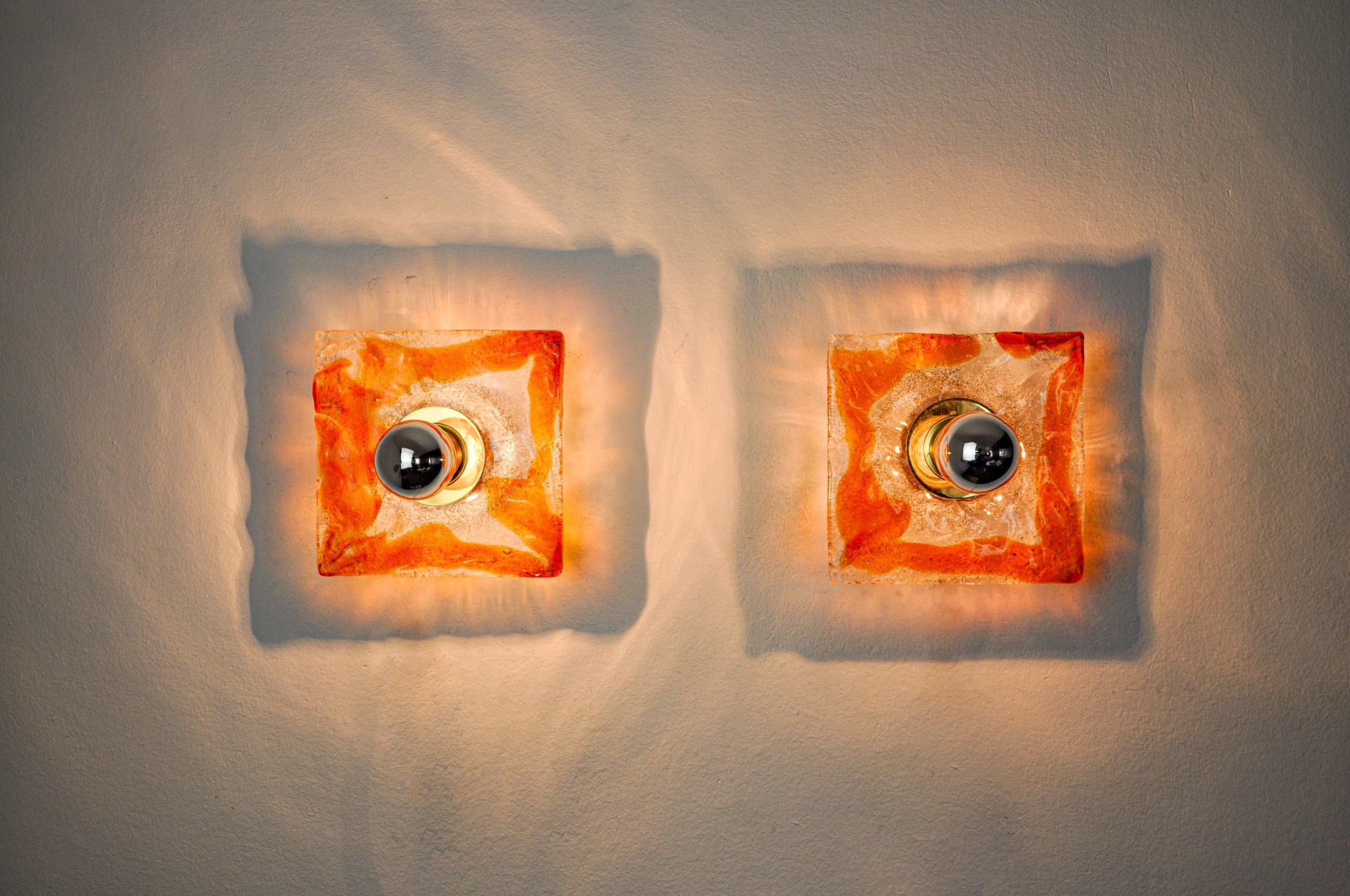 Very beautiful pair of square sconces designed and produced by Murano Mazzega in Italy in the 70s. This pair of sconces is composed of a square, frosted, orange Murano glass sheet supported by a gilded metal structure. Rare design object that will