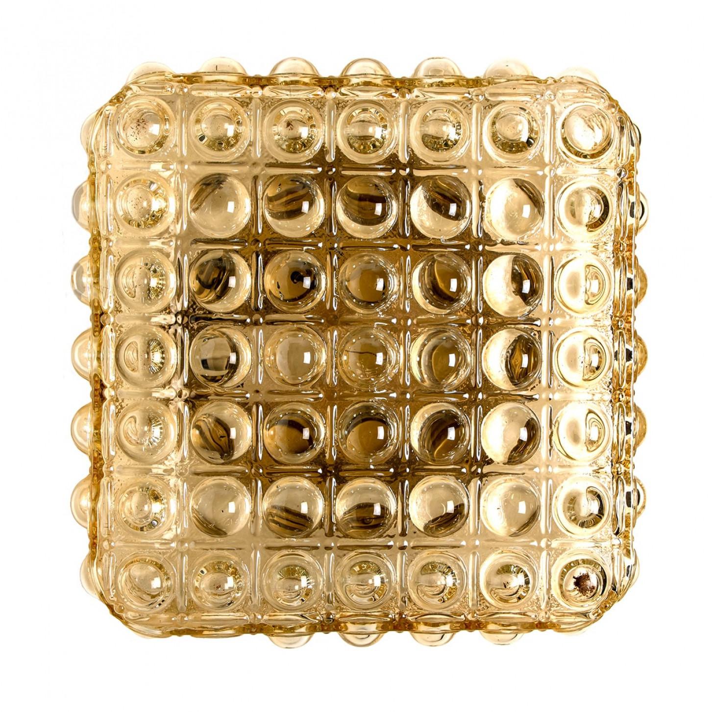 Appliques murales de forme carrée en verre texturé à bulles avec détails dorés. Fabriqué par Glashütte Limburg en Allemagne dans les années 1970. (début des années 1970).

Beau travail. Un design minimal, géométrique et aux formes simples.

Peut