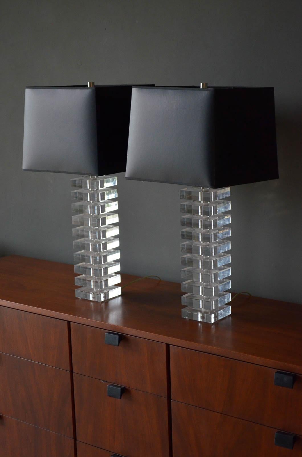 Pair of Stacked Lucite Lamps in the style of Karl Springer, ca. 1970. Beautiful condition lamps include custom black shades with matching silver lining. Original wiring in working condition.

Measure 4