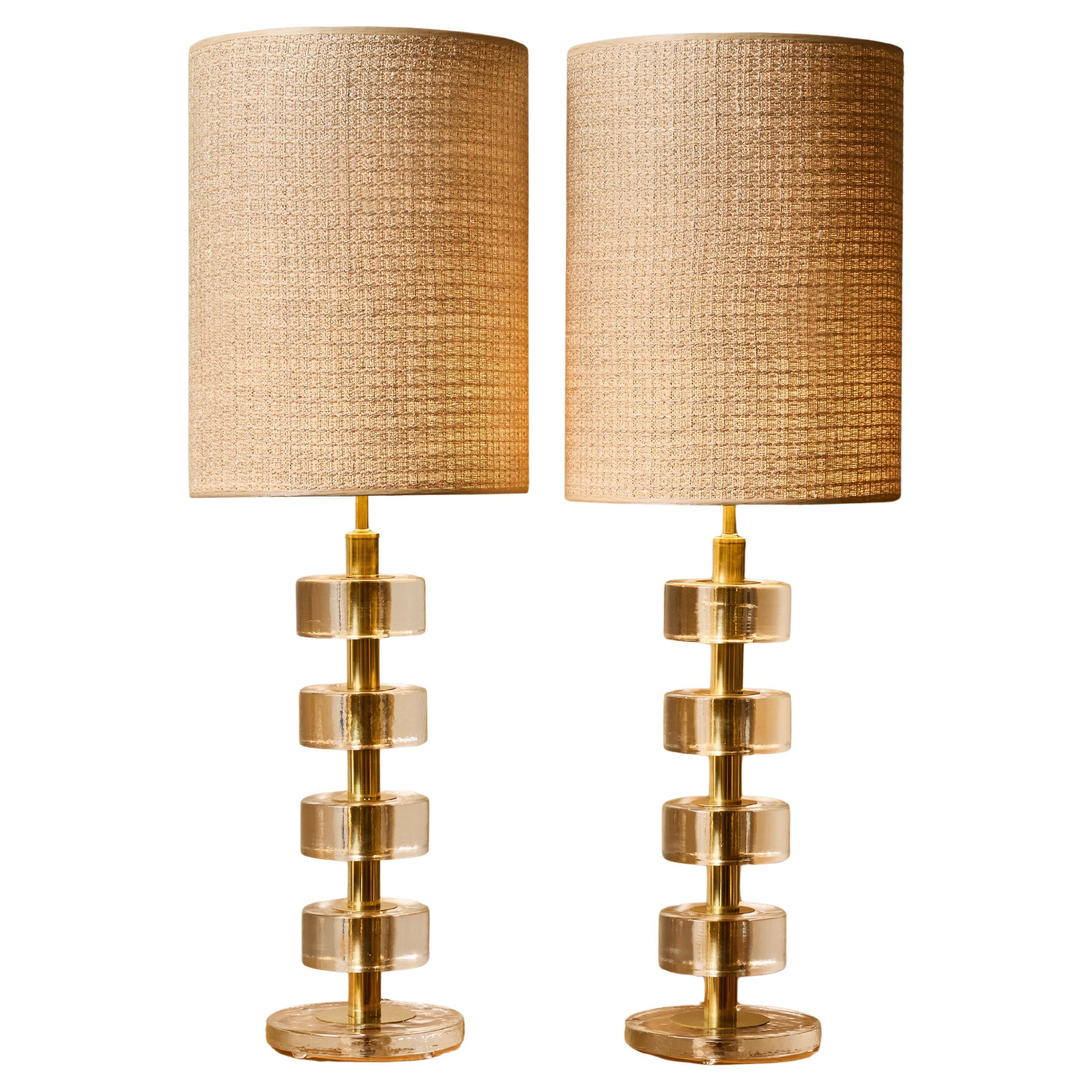 Coppia di lampade da tavolo a disco in vetro massiccio impilate con colonne in ottone lucido in vendita