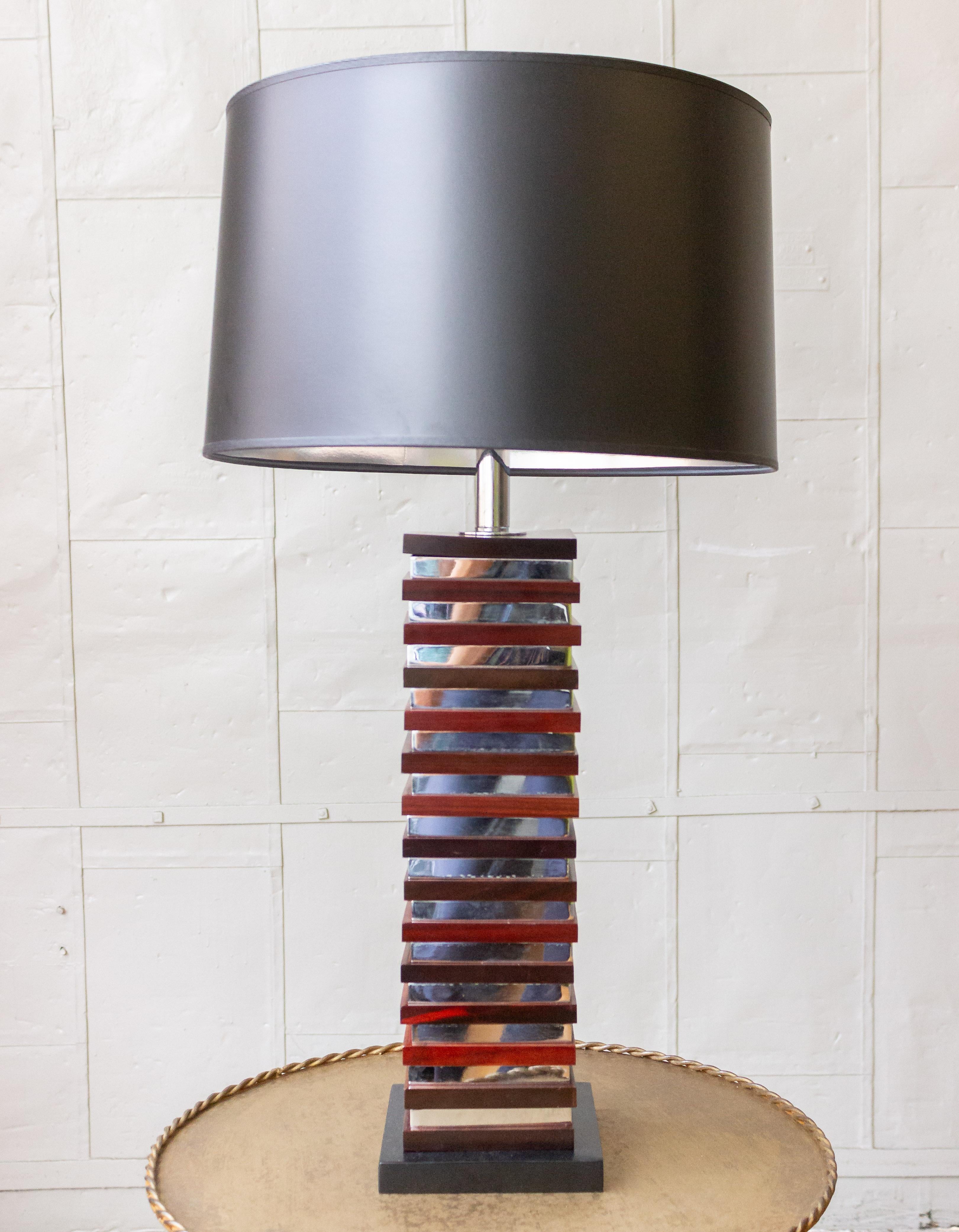 This unusual pair of 1970s French Mid-Century Modern table lamps will enhance any space. These elegant lamps feature alternating squares of rich mahogany and sleek chrome, resting on ebonized square bases. Despite their age, these lamps are in good