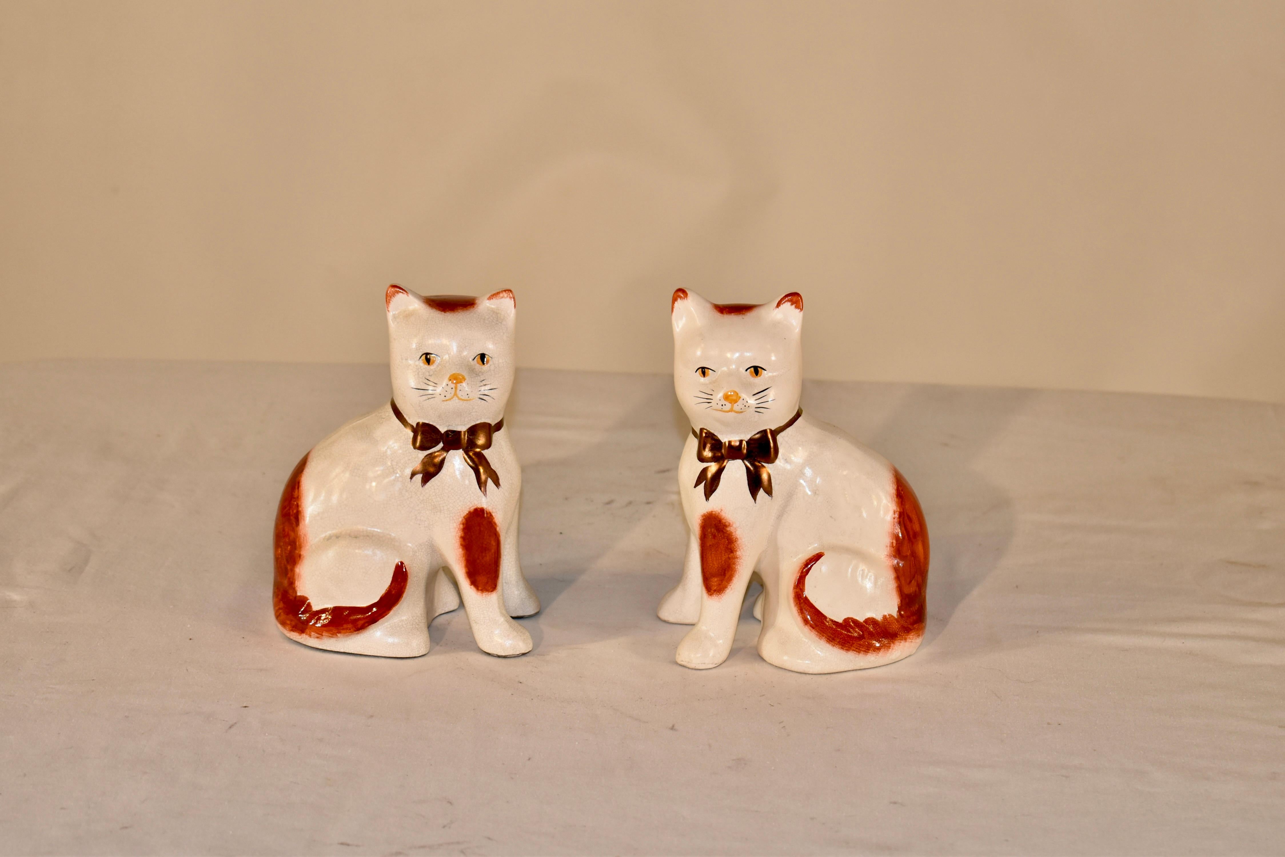 Circa 1970 figuras vintage de  gatos de la región inglesa de Staffordshire.  El gato está decorado en óxido y blanco, y tiene un lazo dorado alrededor del cuello.  Es un modelo bonito, ya que tiene las patas delanteras separadas.  Son un par