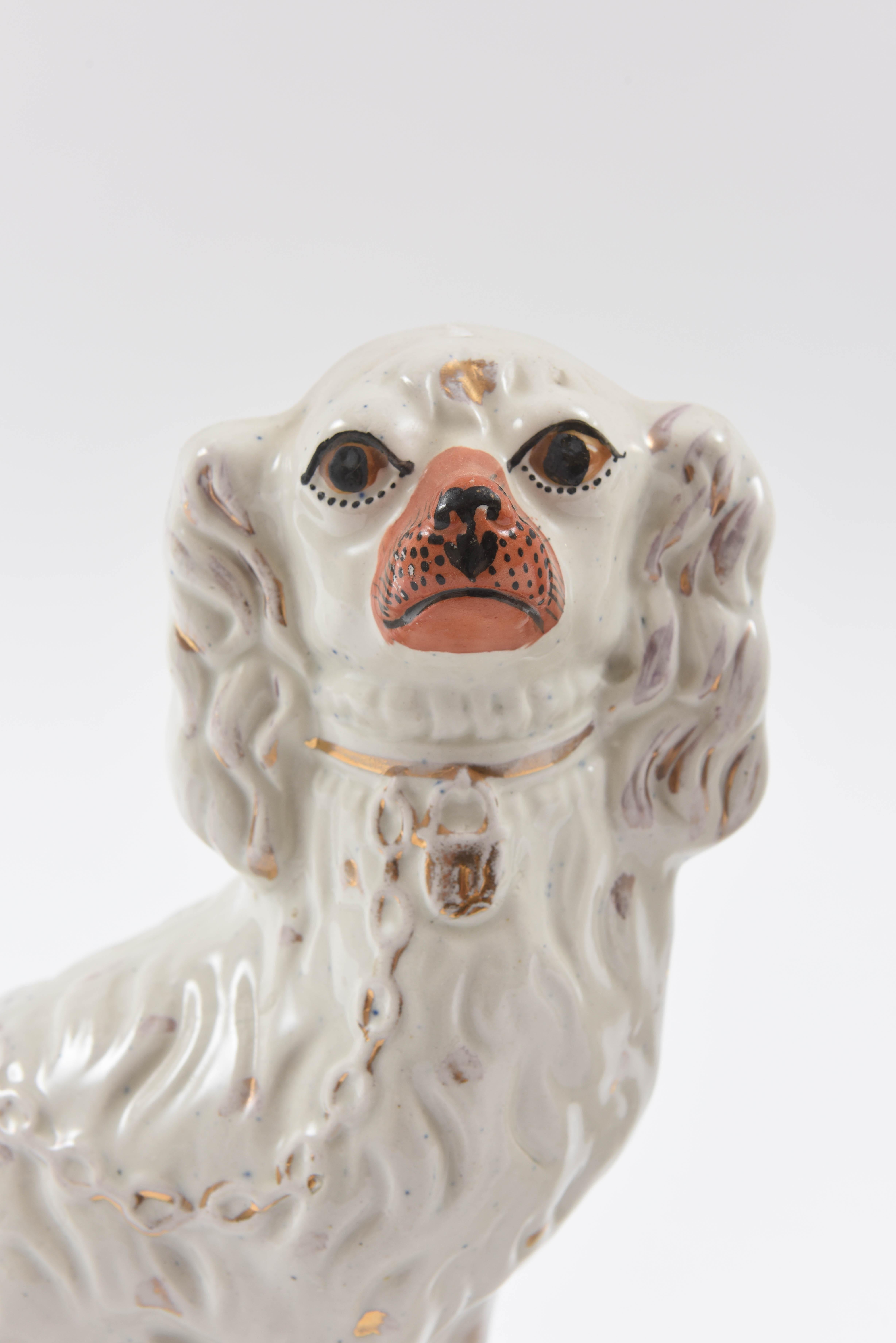 A Classic pair to grace your mantel or book cases. This pair of mid-19th century English porcelain dogs feature the whimsical and charming look, white ground, gold locket and orange snout. A nice size and in good antique condition.