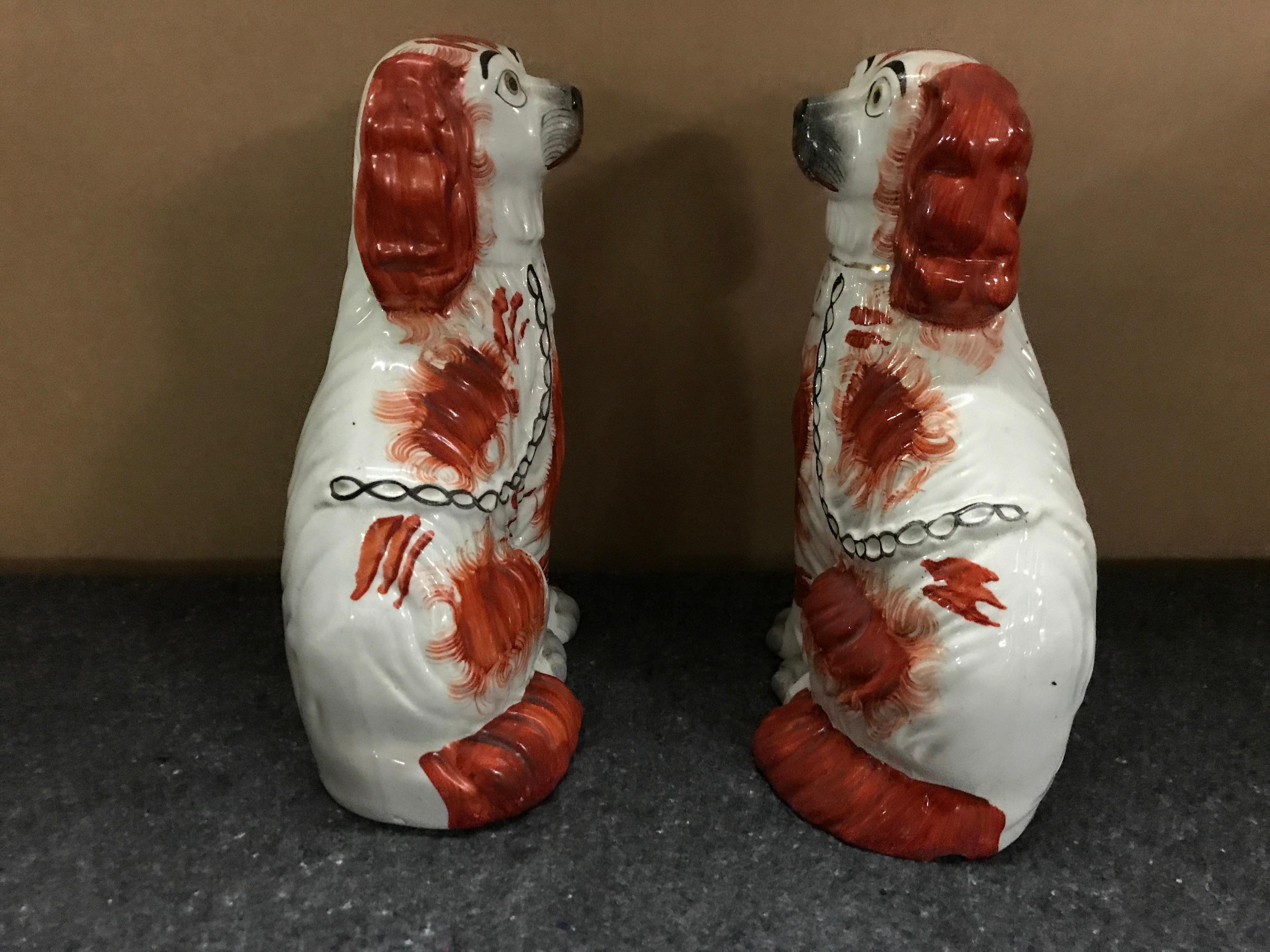 Pair of Staffordshire seated red spaniels each one well painted with expressive faces.
  
 