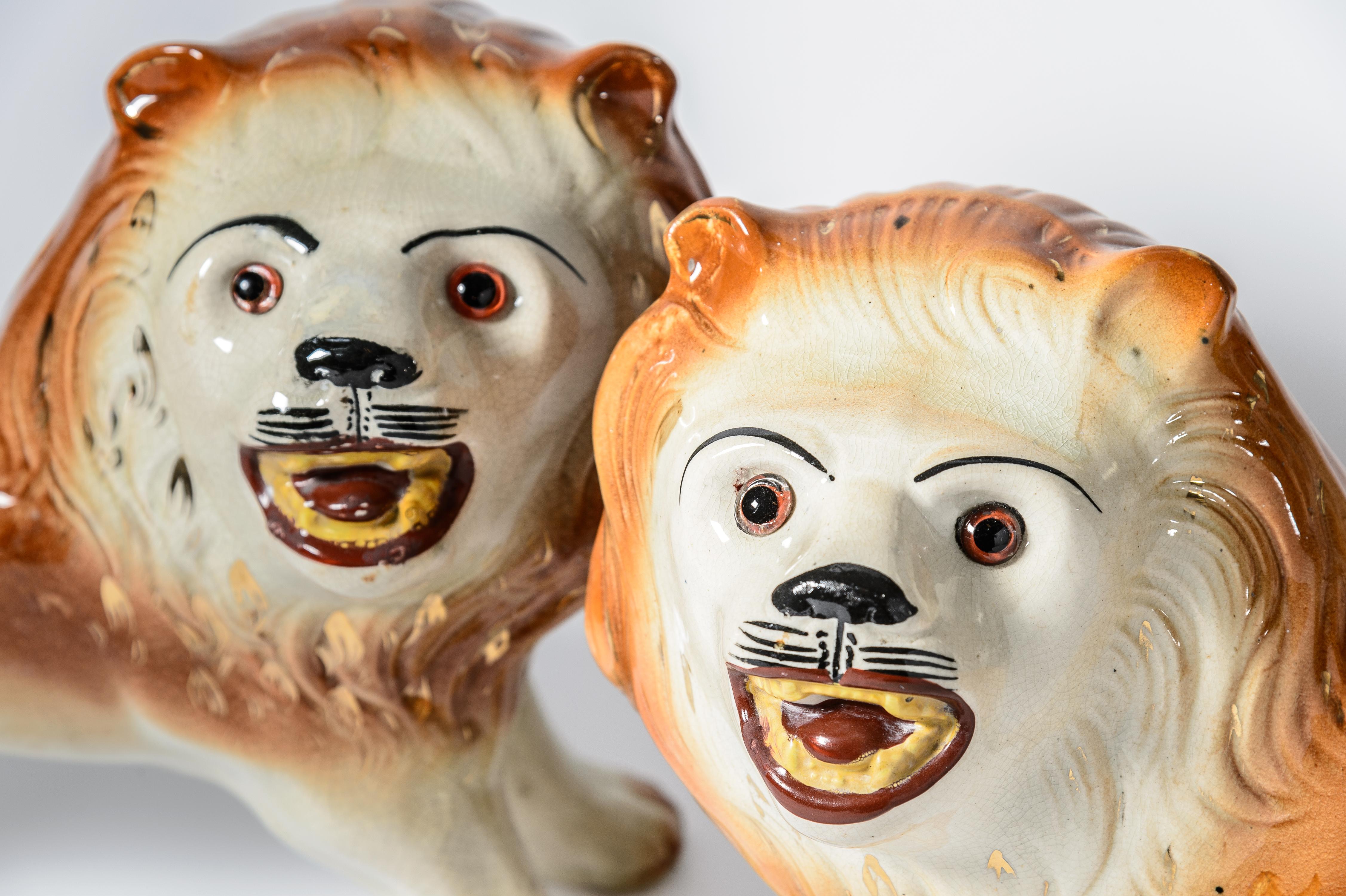 A classic and handsome pair of Staffordshire Lions from the mid 19th century. This pair has full and separated legs that are highly detailed right down to their paws. Original glass eyes, and whimsical painted faces will certainly charm. They are in