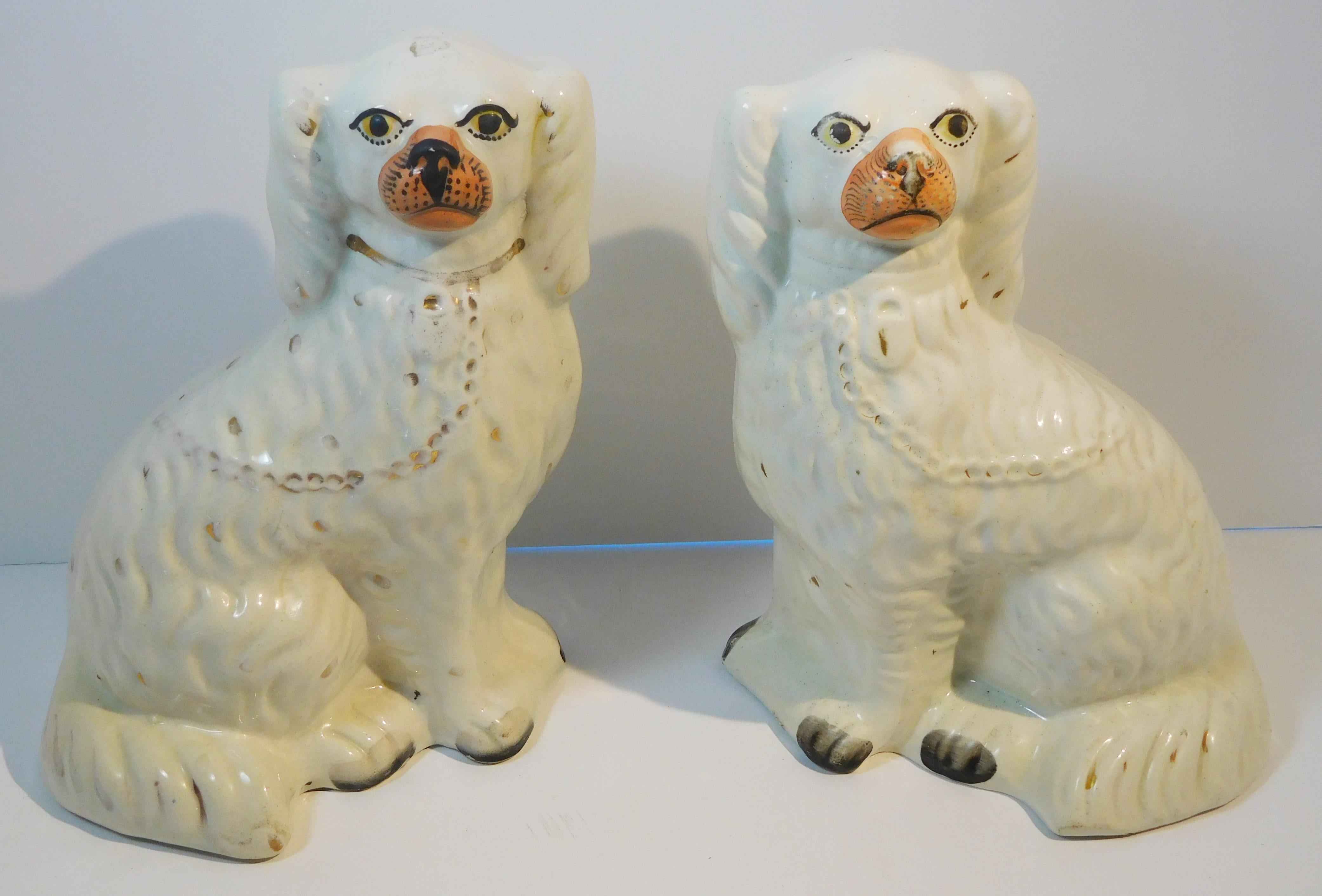 This handsome pair of King Charles Spaniel figures features white bodies, random golden spots and golden collars with locks and leads, sienna-colored snouts and eyeballs and black paws, eyelashes and pupils. The figures are fully rounded and are