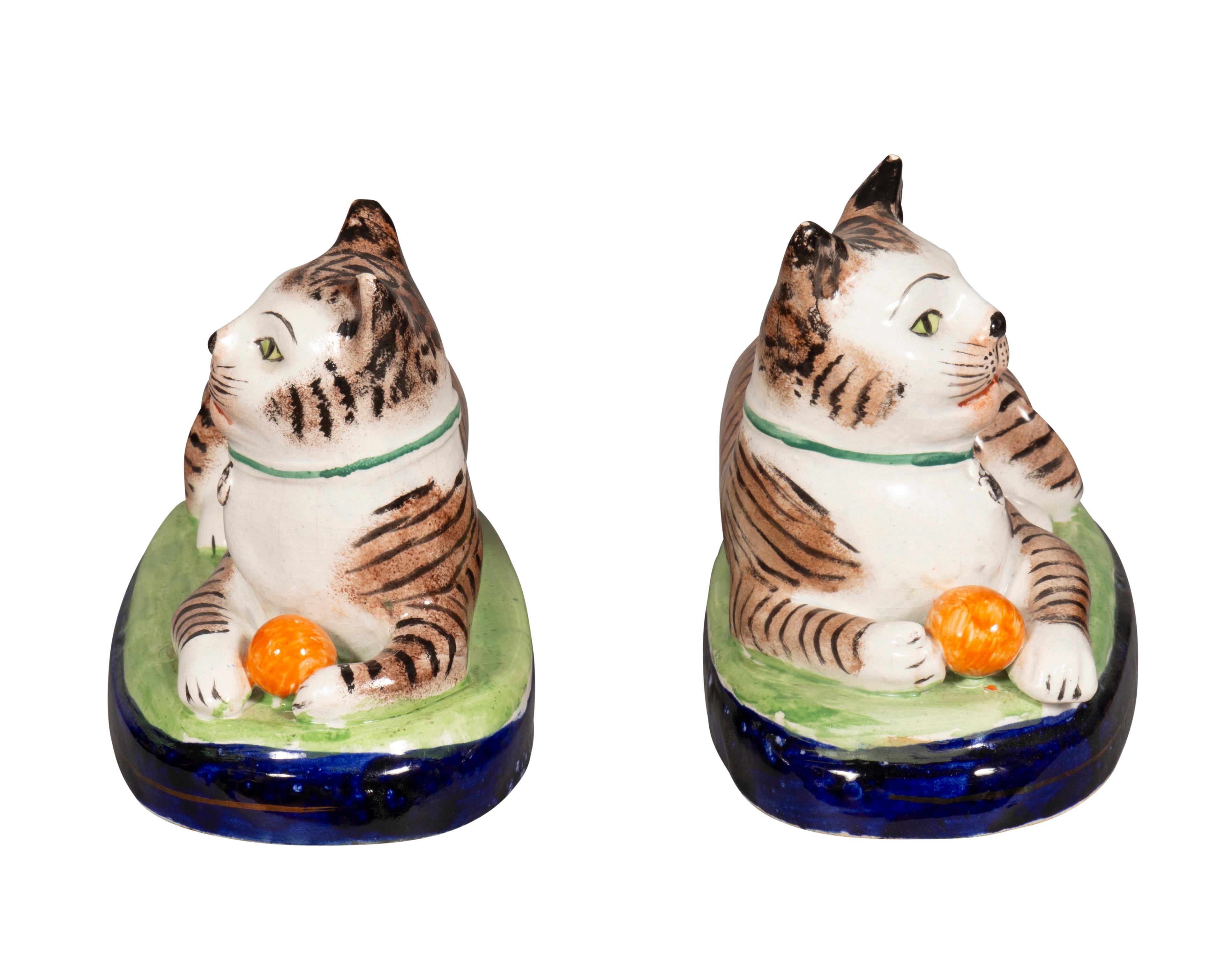 Each cat reclining with a ball between their feet. Nicely painted. Old price tag of 3,500.