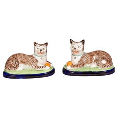 Paire de chats couchés en poterie du Staffordshire