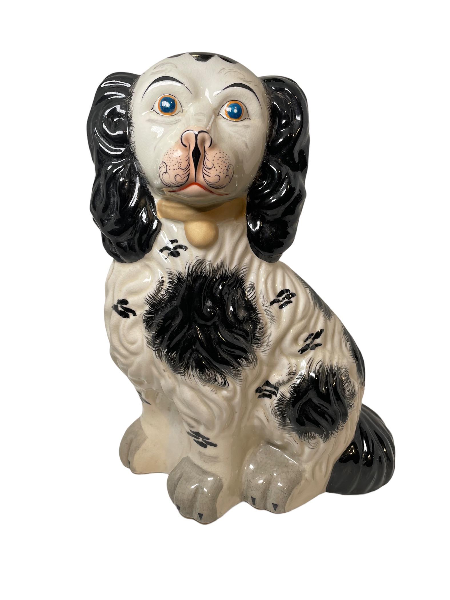 This is a pair of Staffordshire like pottery dogs sculptures. They are hand painted black and white. They have curly hair and very expressive brown eyes. A gold collar adorned their neck.