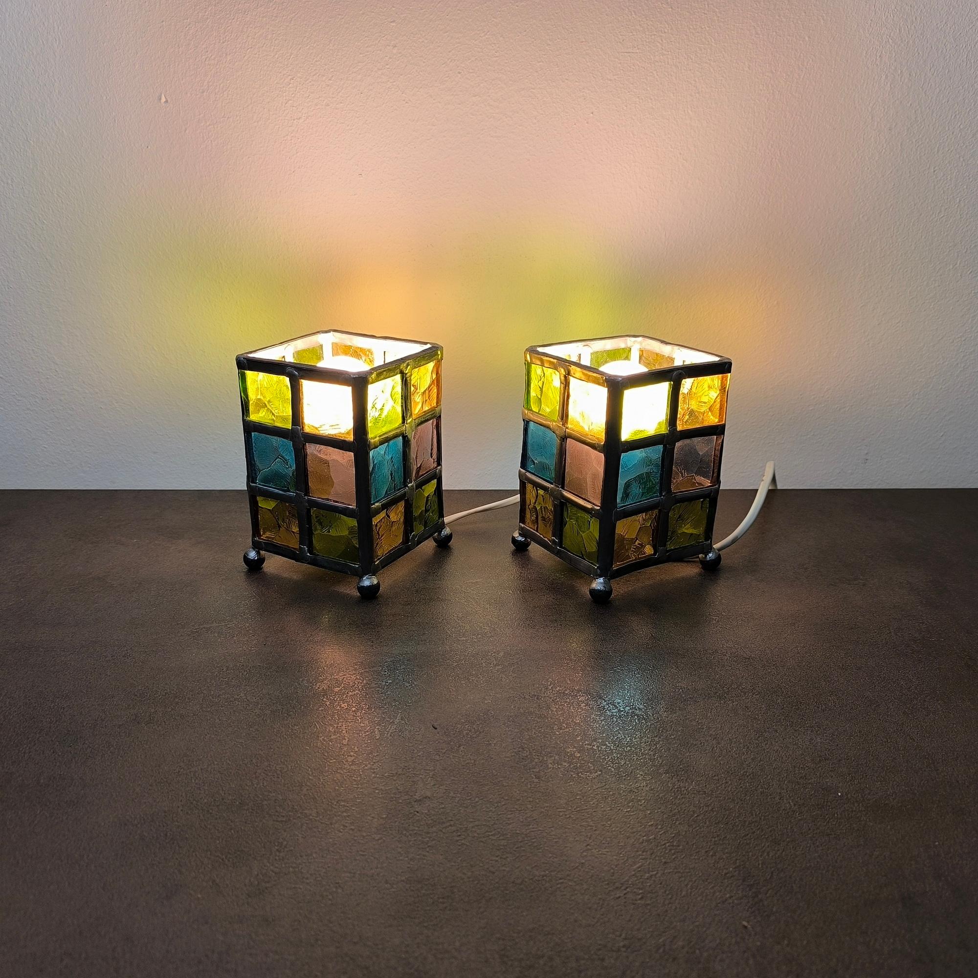 Pair of Stained Glass Lamps in Regular Quadrangular Prism Form, Midcentury Modern Style
A vibrant pair of stained glass accent lamps, each crafted in the form of a regular quadrangular prism. Composed of a grid of richly textured glass tiles in