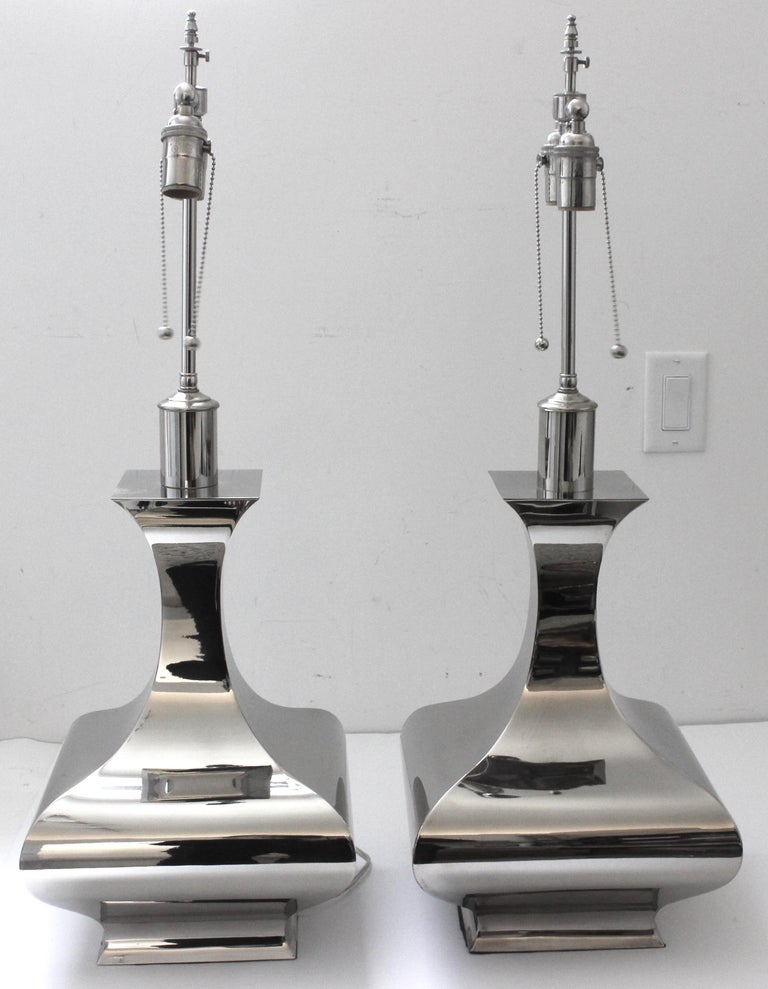 This stylish pair of vase form, stainless steel table lamps are very much in the manner of pieces created by Tommi Parzinger and James Mont.