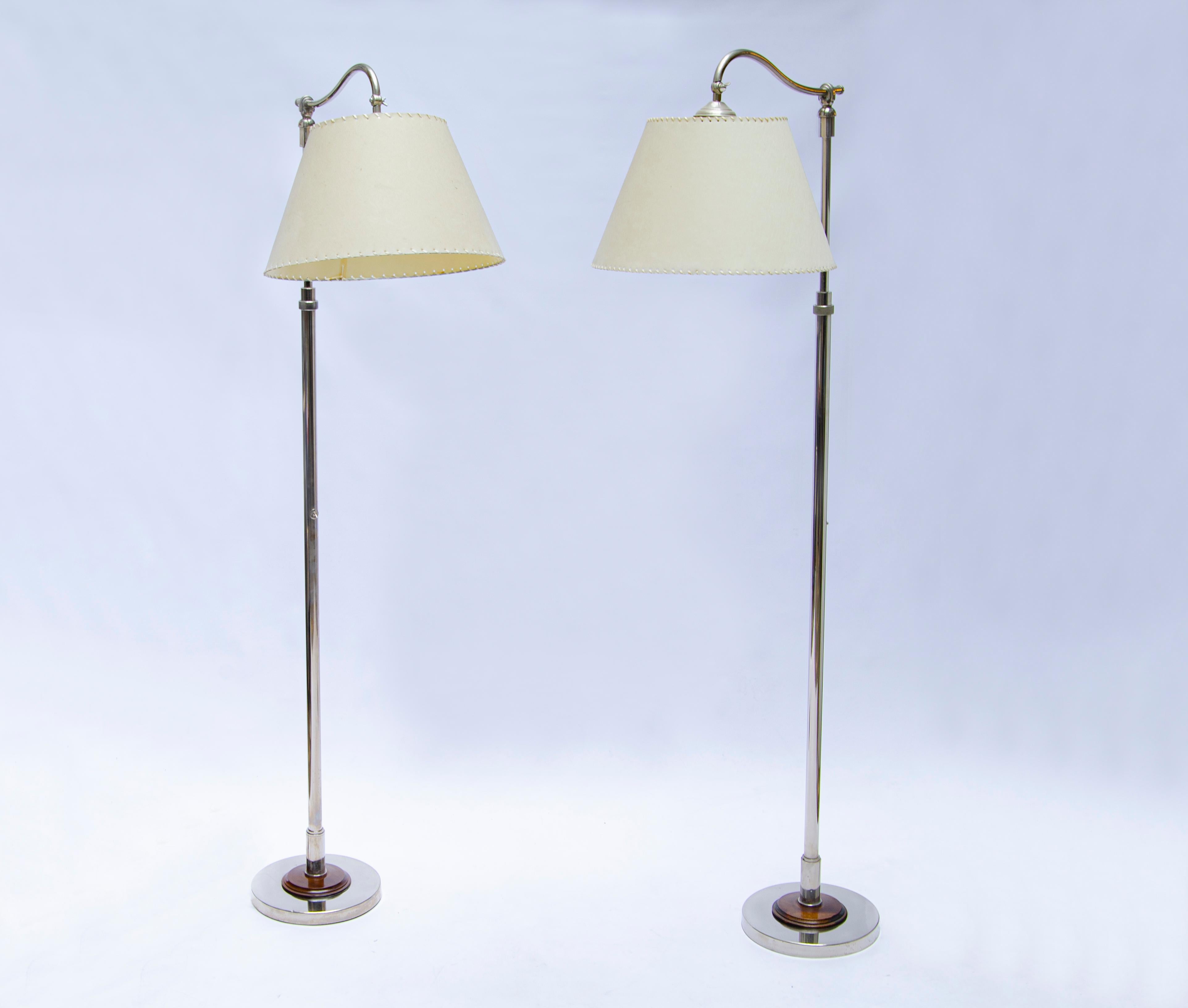 Pair of standing lamps with adjustable height by COMTE. The lamp has a mechanism to adjust the heights as well to change the direction of the shade. Produced in chromed bronze with caoba wood details.

Argentina, CIRCA 1940.