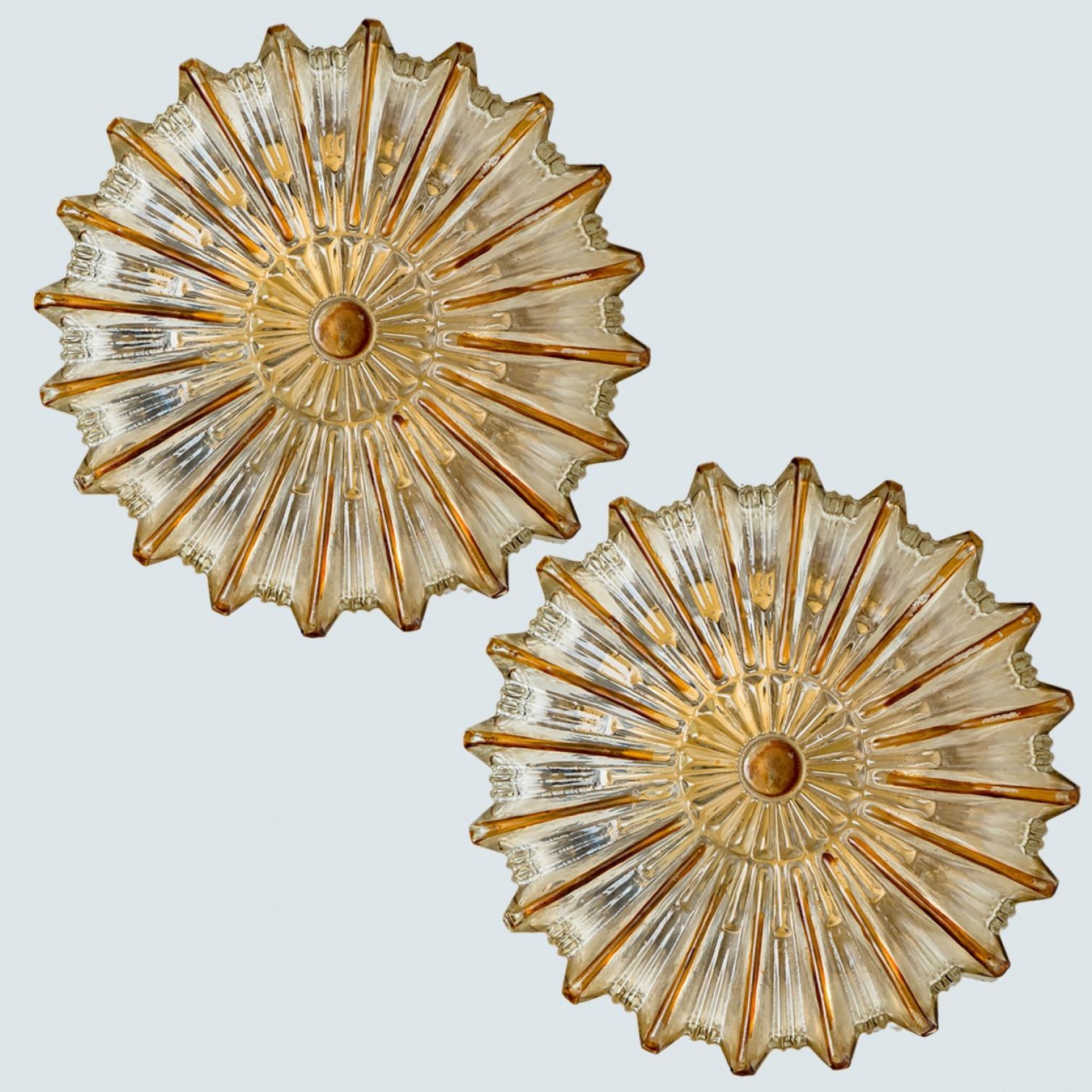 Pair of Clear and amber colored bubble glass wall light designed in the style of Helena Tynell around 1960-1970 in Europe, Germany. The rich textured bubbled glass gives a wonderful glow. The star-shaped glass is mounted on a gold colored metal back