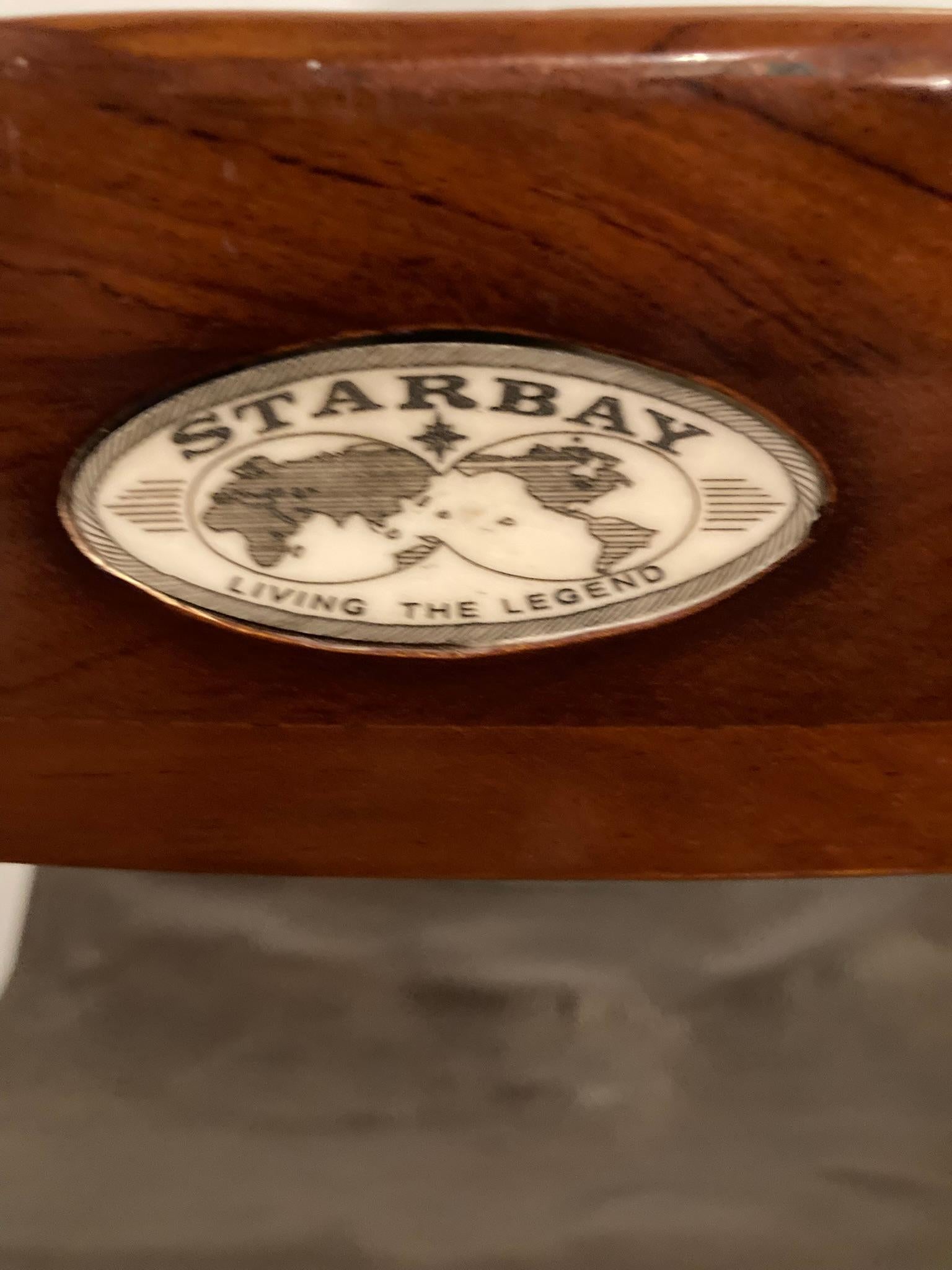 Ein Paar Starbay Bermudes Folding Rosewood Yacht Chairswith Ledersitze und mit Etiketten.  Die aus hochwertigem Palisanderholz gefertigten Stühle vereinen Langlebigkeit mit zeitloser Eleganz und eignen sich daher sowohl für den Innen- als auch für