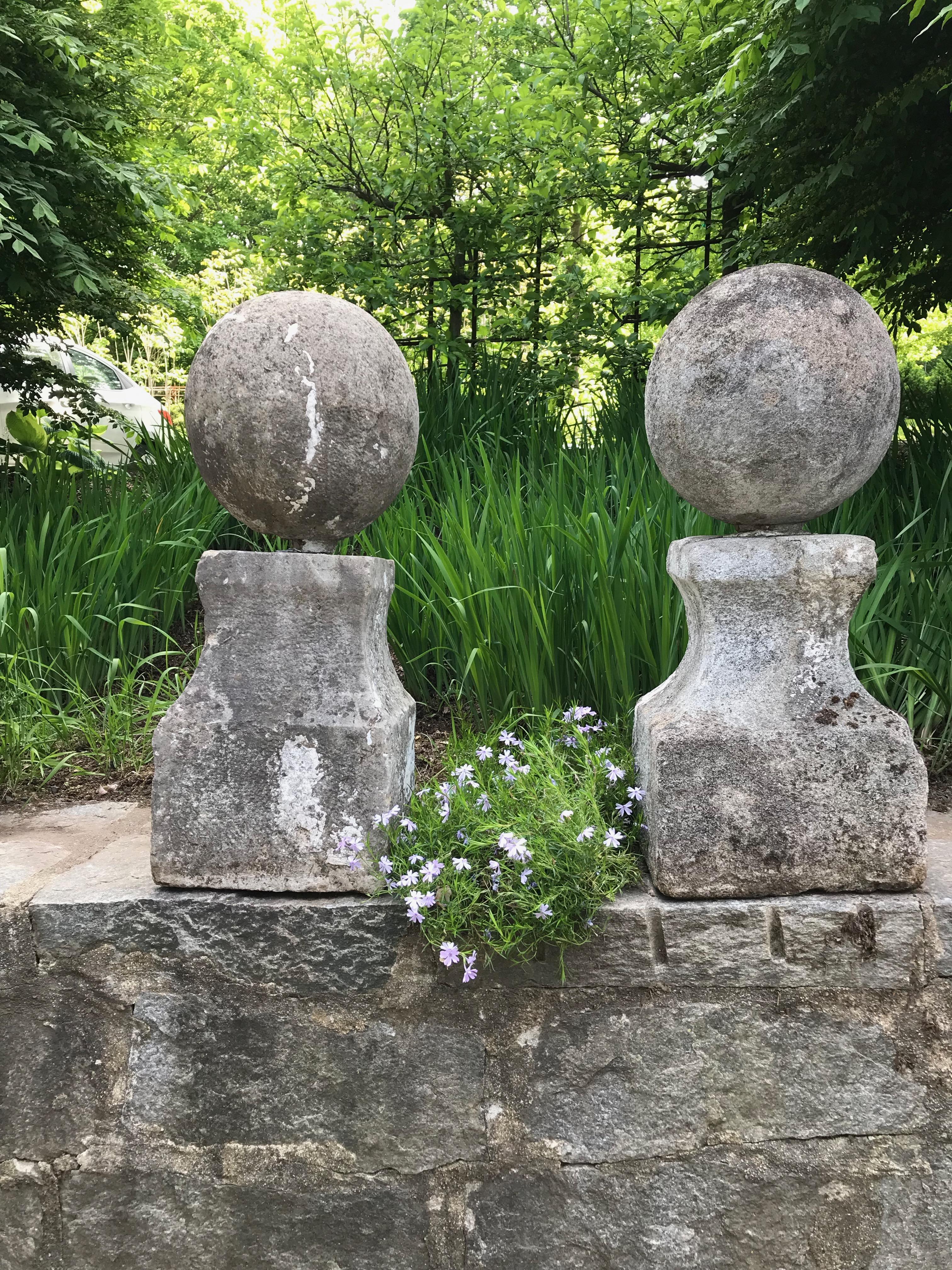 This pair of exceptional hand-carved 18th century limestone ball finials is certainly not perfect, but they are completely authentic and have great form and presence. With come remnants of old white paint that we believe mostly covers old repairs,