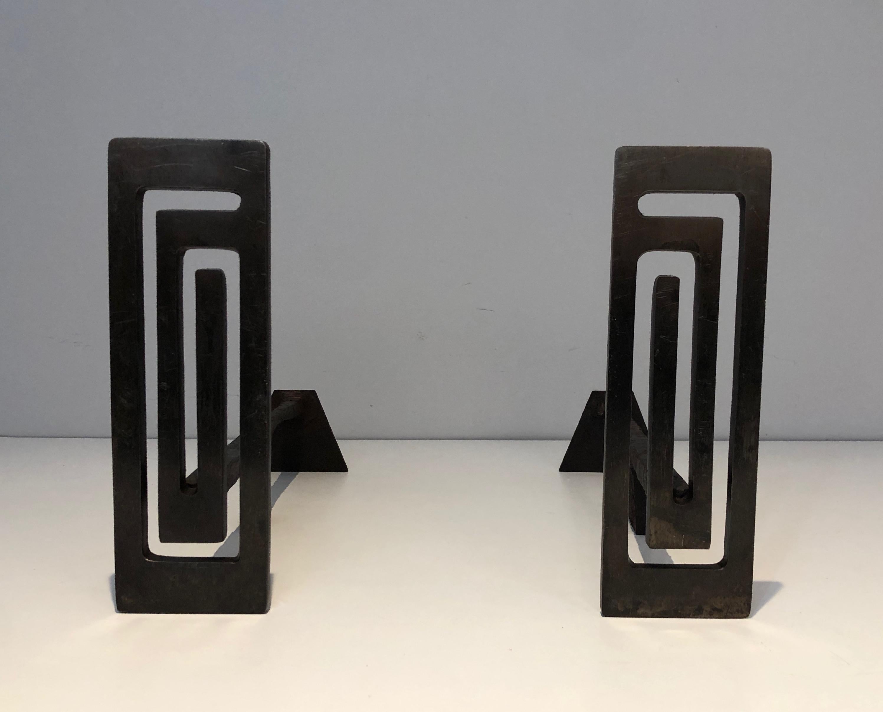 This pair is Modernist andirons is made or steel and wrought iron. The steel part presents a nice modernist design. This is a French work, circa 1970.