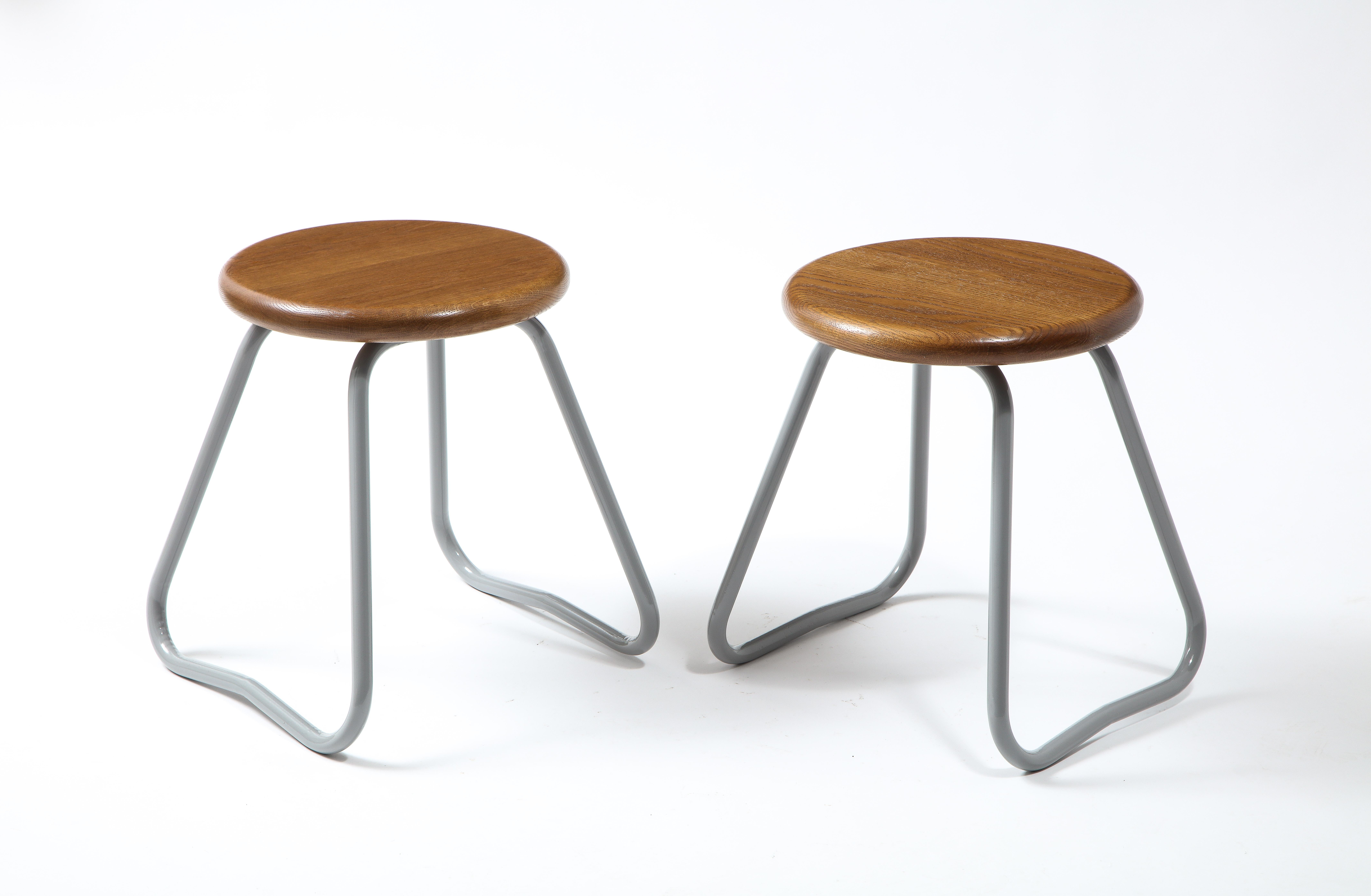 Pair of bent steel tubing stools enameled grey with newly refinished oak tops.