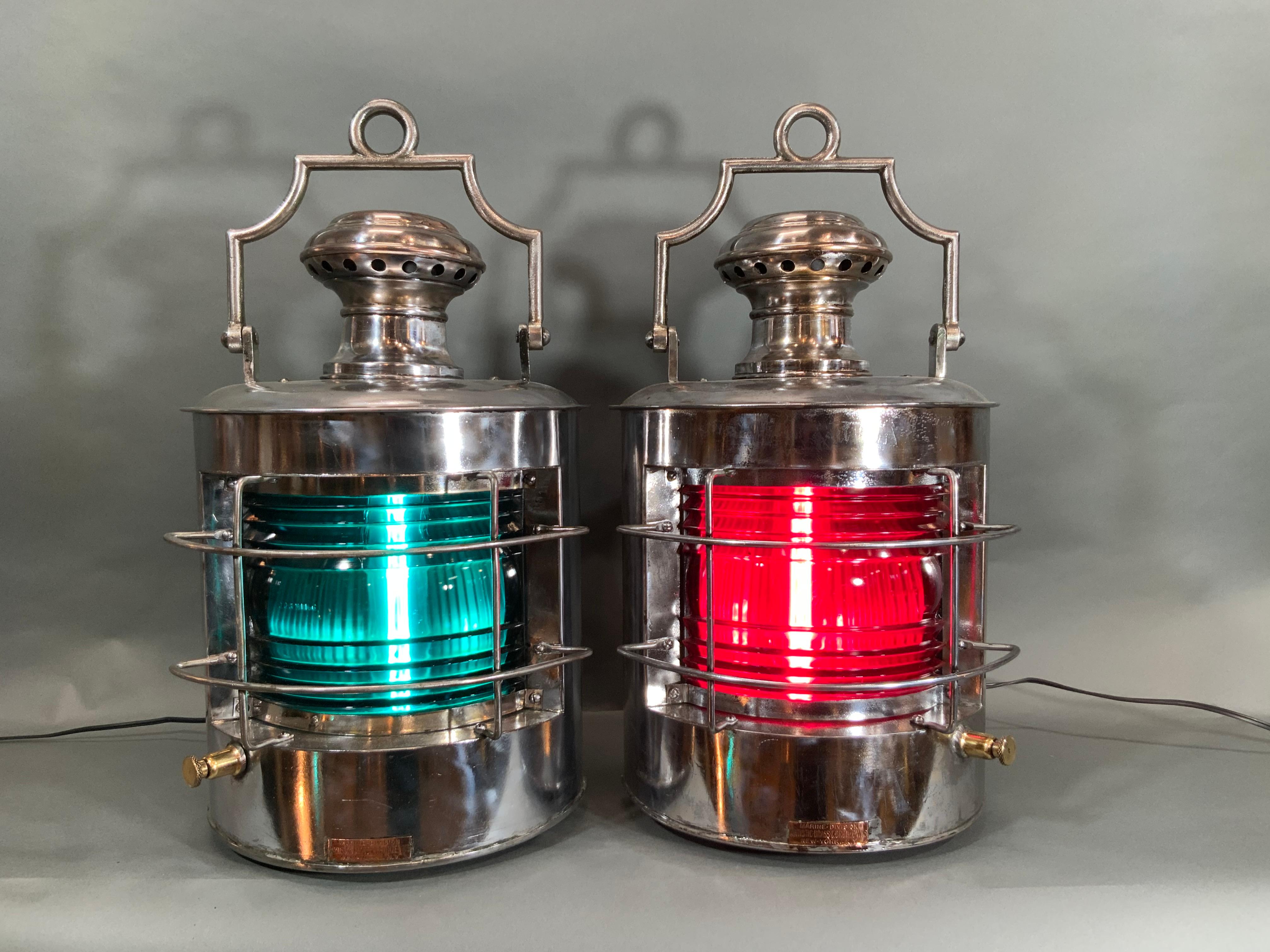 Pair of ship's lanterns, port and starboard, with polished steel cases that have been stripped and meticulously polished and lacquered. This is a first class pair of lanterns with copper badges from Marine Division Artistic Brass and Bronze Works of