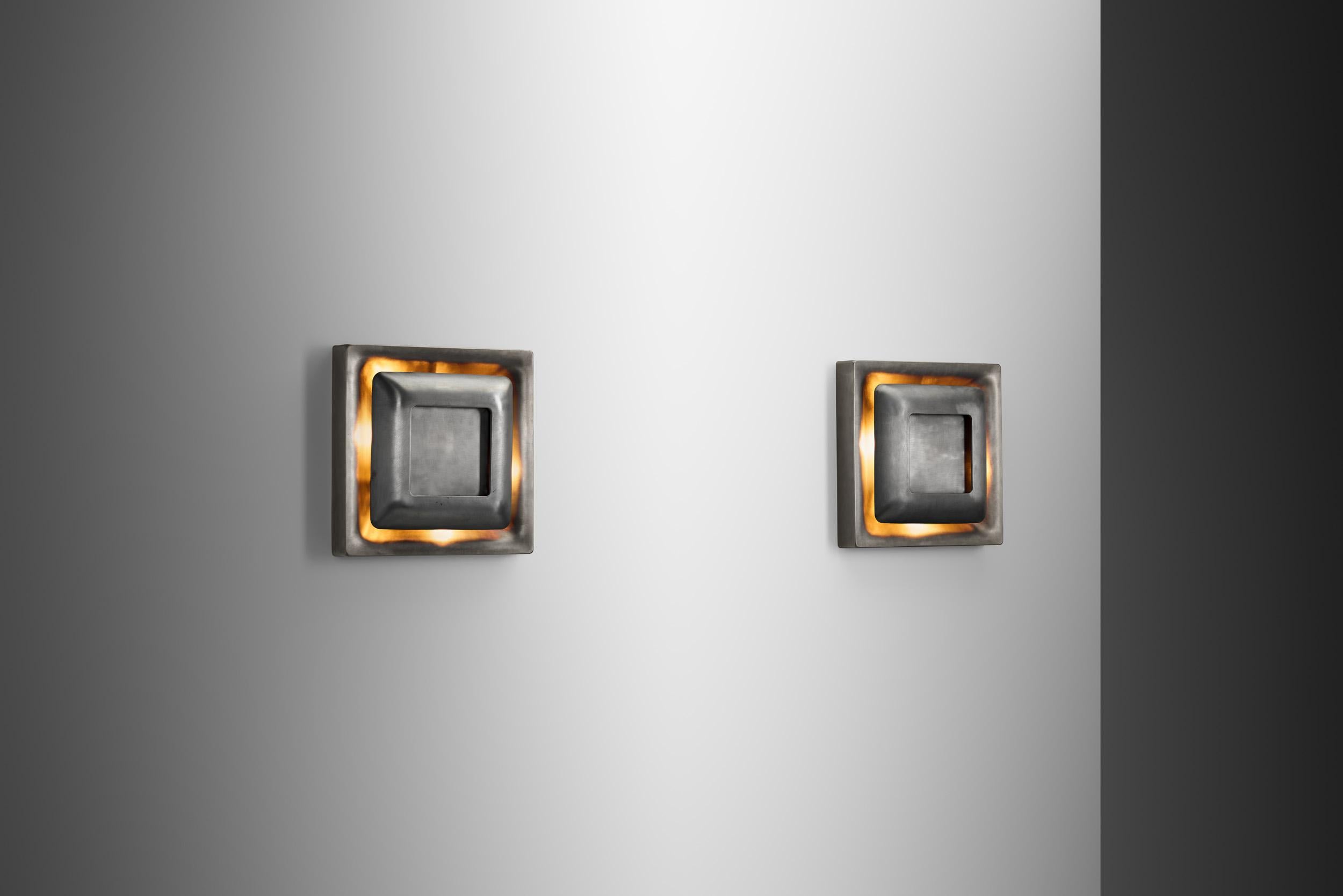 Este par de lámparas de pared de la empresa alemana Doria, es un sorprendente ejemplo de diseño de mediados del siglo XX que mezcla materiales industriales con elegancia escultórica. El aspecto futurista se consigue mediante el diseño sencillo pero