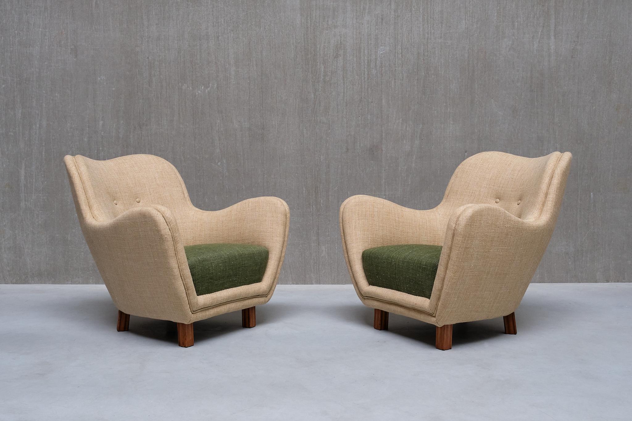 Cette rare paire de fauteuils a été produite par Sten Wicéns Möbelindustri en Suède dans les années 1950.

Le design élégant se caractérise par ses lignes arrondies et organiques, créant une silhouette somptueuse et saisissante. La forme