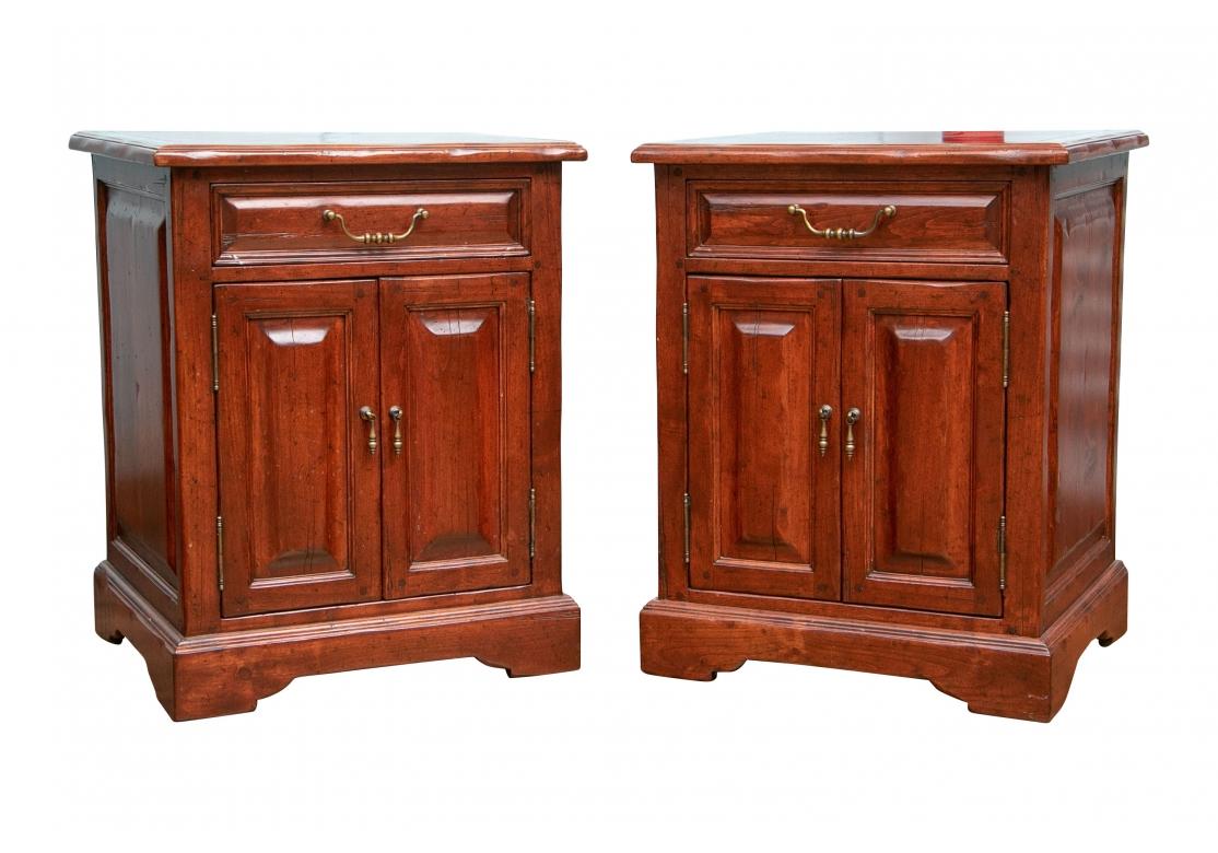 By The Sterling Collection. With 3/4 banded plank tops and an apron drawer with brass bale pull. A double door cabinet below with brass drop pulls and a single shelf inside. With carved side panels and raised on a carved base. The finish with faux