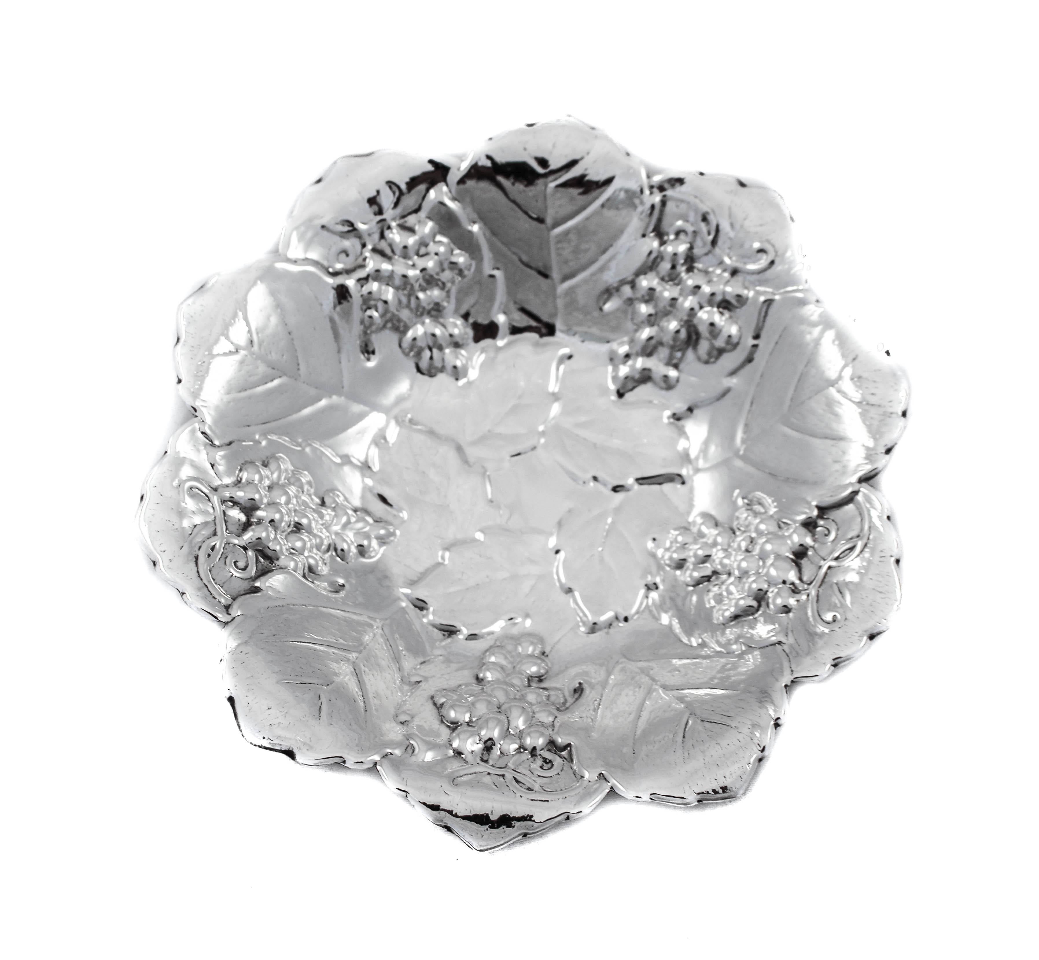 Being offered is a pair of sterling silver dishes by the Poole Silver Company. They have scalloped edges with clusters of grapes on vines coming down the side towards the center. The center is decorated with a group of five leaves, in keeping with