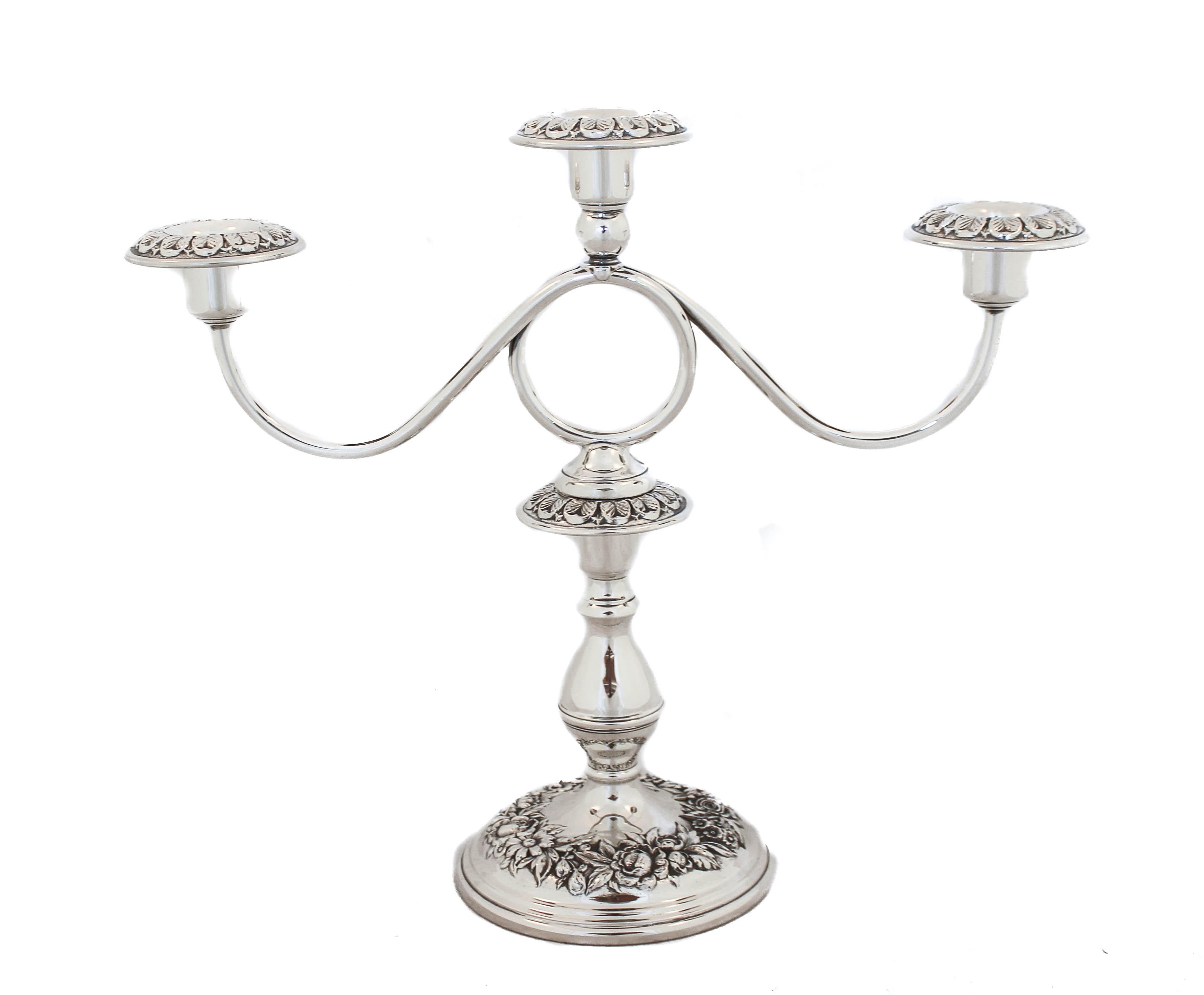 We are proud to offer you this pair of sterling silver candelabras in the “Repousse” pattern by S. Kirk & Son of Baltimore, Maryland. Each candelabra has three-branches, a total of six lights. Around the base there is a circle of blown out flowers