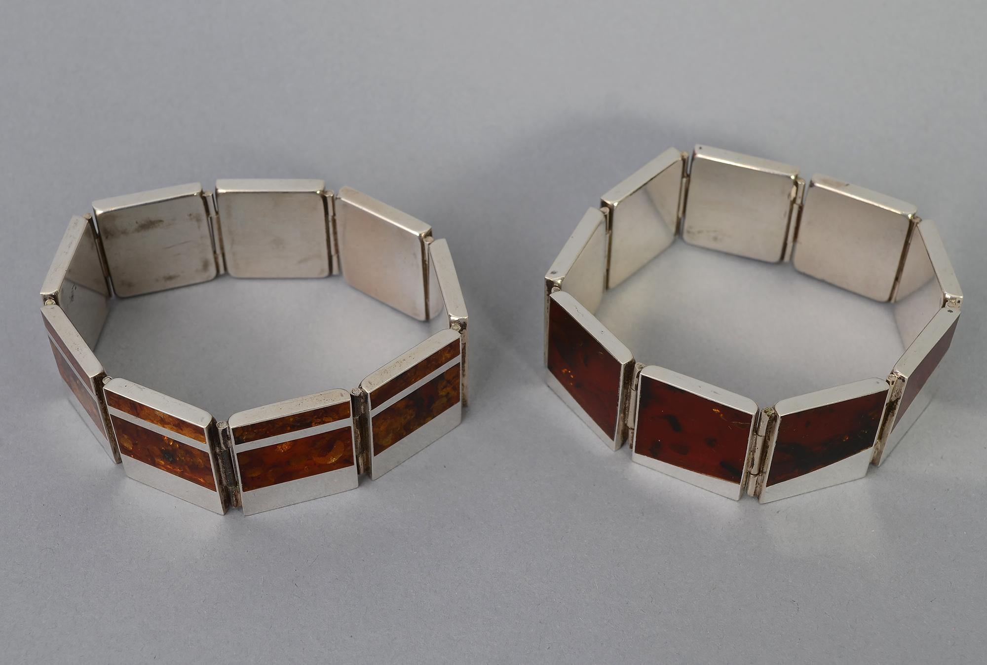 This is a pair of Modernist fraternal twin bracelets of silver and amber. They are made by the same hand; have the same material and size but slightly different in design.
The bracelets measure 15/16