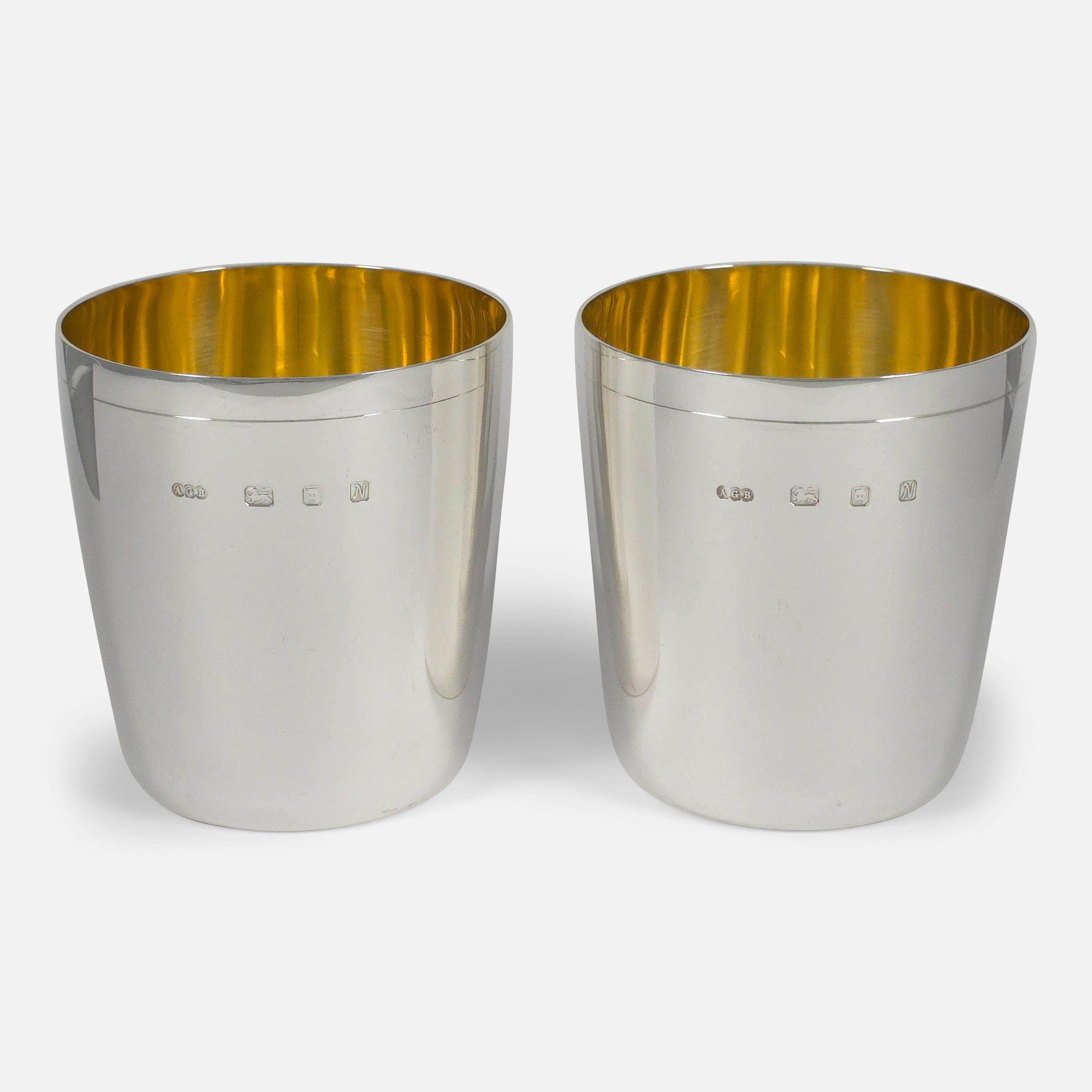 1987 sterling silver beakers by Gerald Benney, featuring tapering circular forms with single line decoration and gilded bowls. The beakers come in the original box, including a personal note from Gerald Benney dated 23 Feb 1989.

• Assay: .925