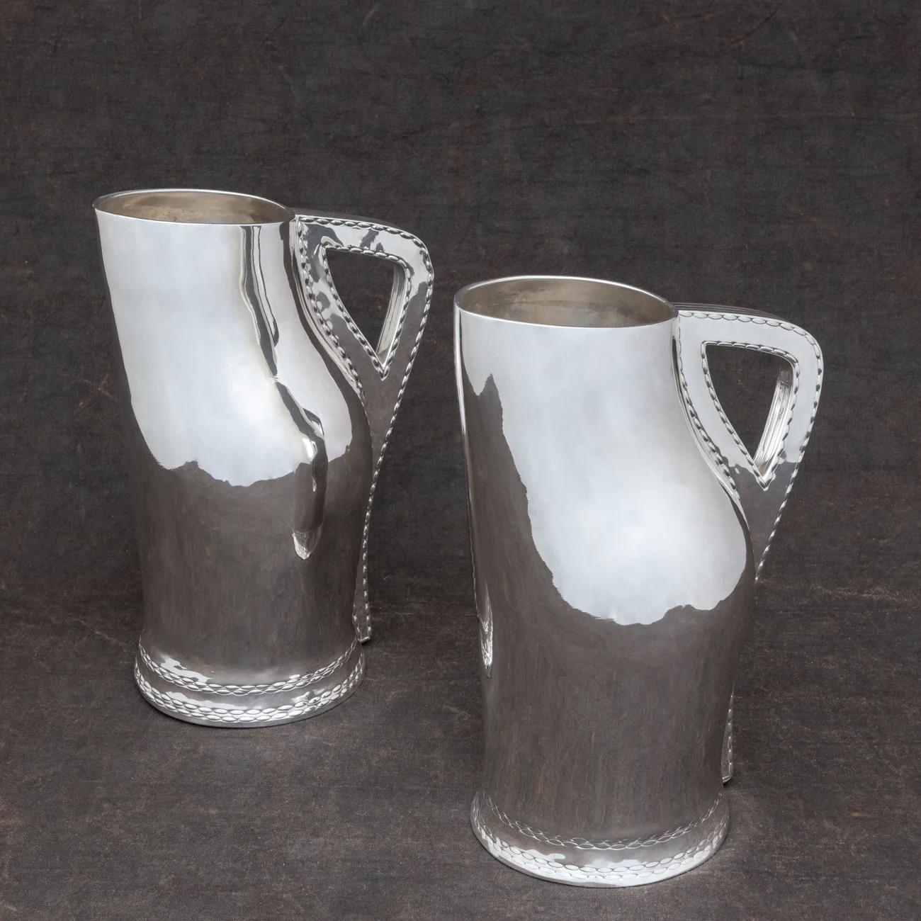 Spectacular pair of sterling silver jugs by Elkington & Co. Hallmarked London, 1884. Mimicking the design of English blackjack leather jugs typically seen in the 16th and 17th century.

Dimensions of each: 28cm/ 11 inches (height) x 13cm/ 5?
