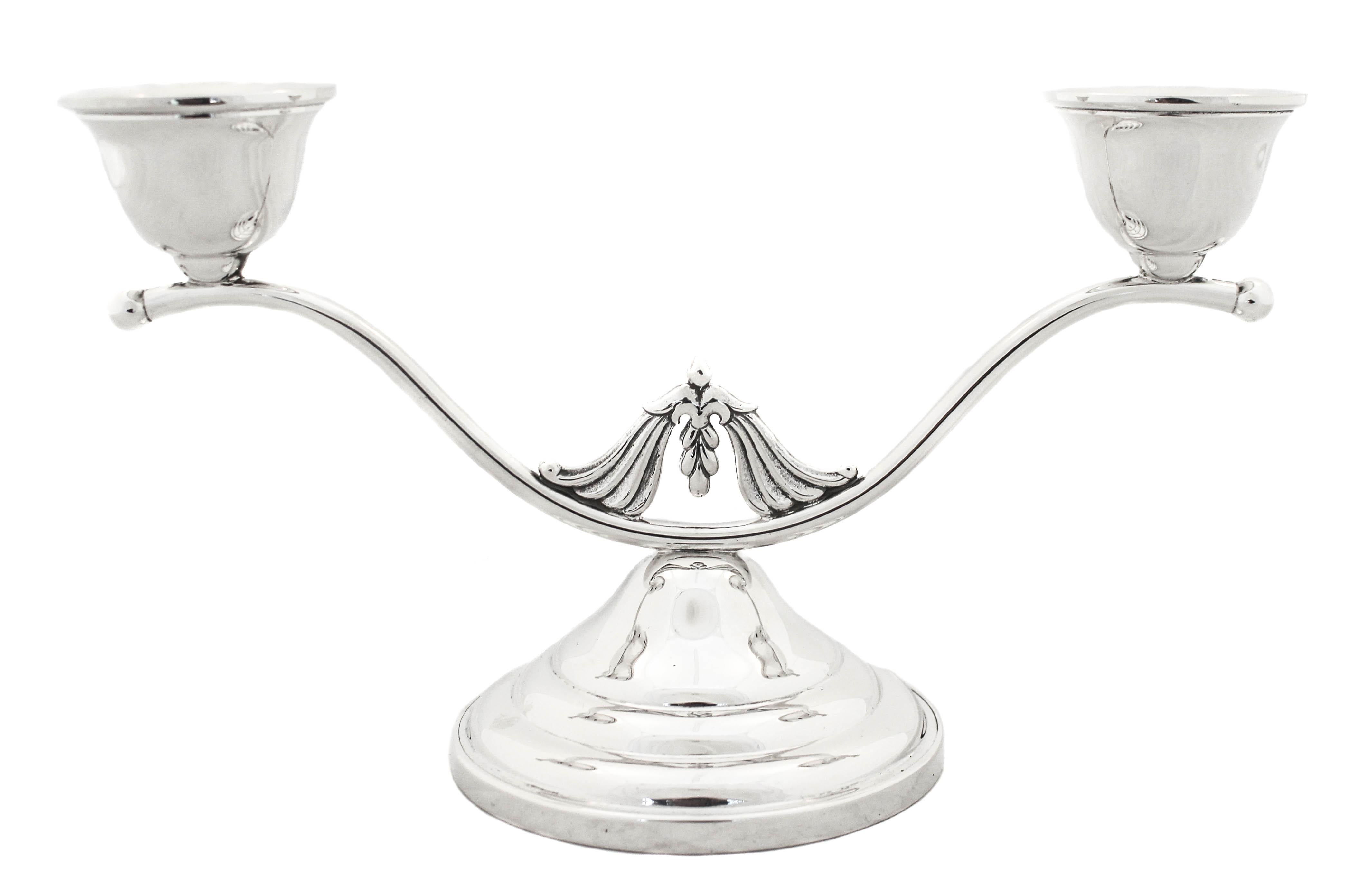 We are happy to offer you this pair of sterling silver candelabras by The Randahl Shop of Chicago, Illinois. Each candelabra has two branches that swirl outwards, in the center a decorative piece sits in the valley. The candelabras are modern with