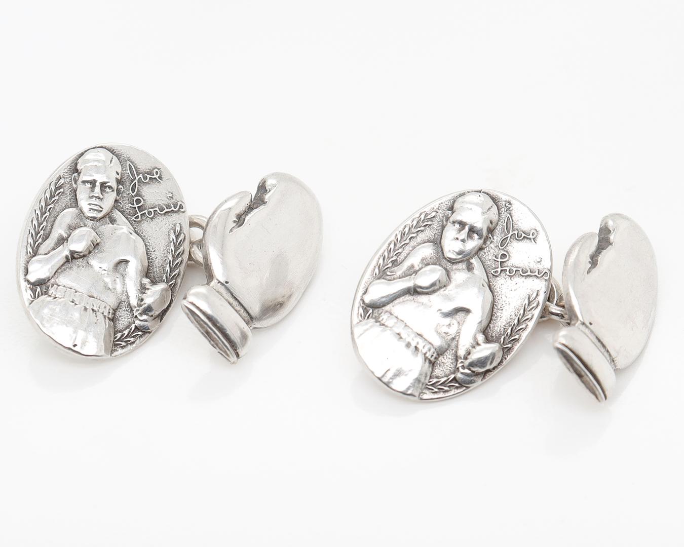 A fine pair of vintage pugilist-themed cufflinks.

In sterling silver.

With an embossed figural depiction of Joe Lewis to one side and boxing glove back. Each connected by a link chain. 

Marked Sterling to the reverse.

Simply terrific Mid-Century