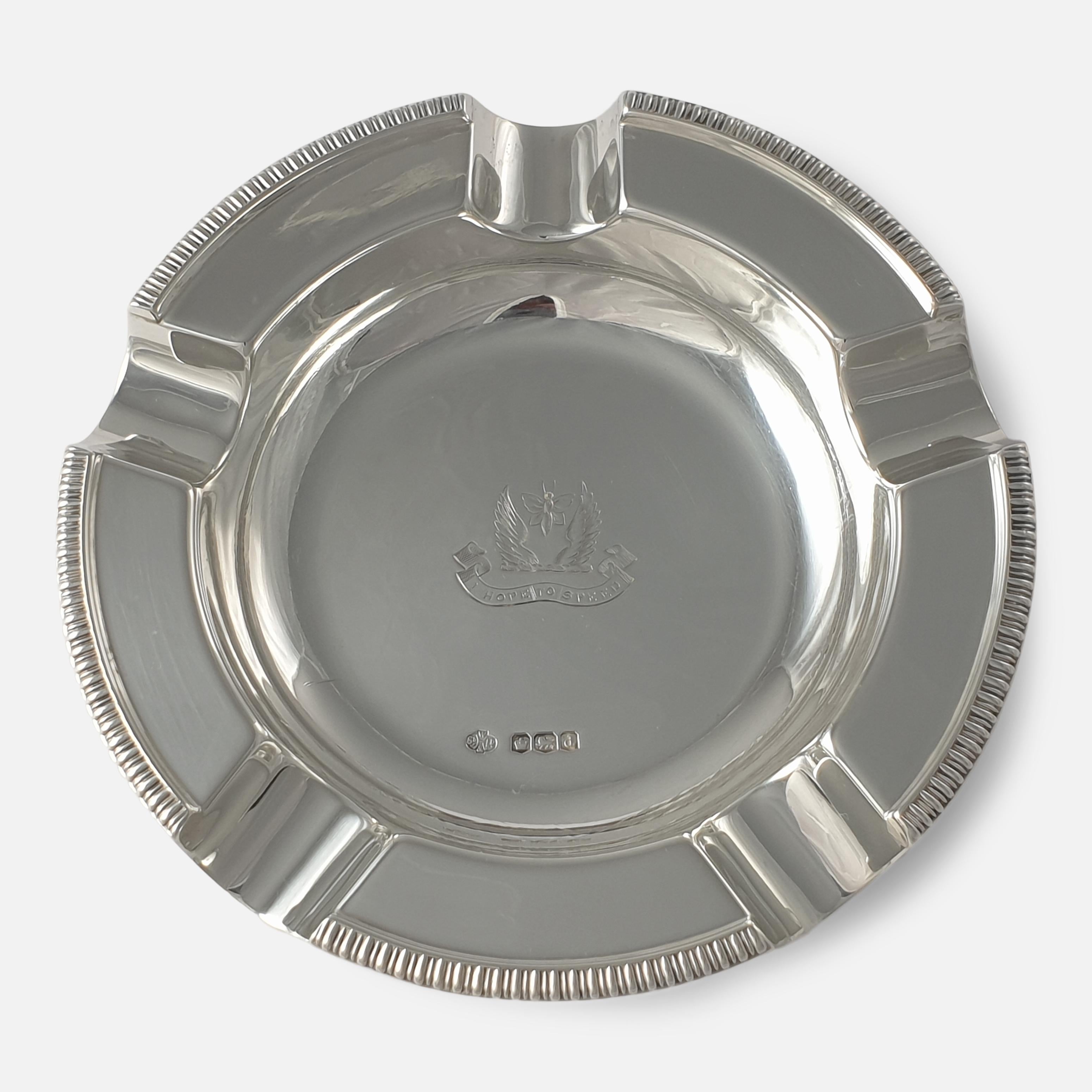 A pair of George V sterling silver crested ashtrays. The ashtrays are of circular form, with gadrooned rim, and engraved with the Butterwick crest. The ashtrays are made by William Hutton & Sons Ltd, stamped with Sheffield marks, 1919 & 1921 (date