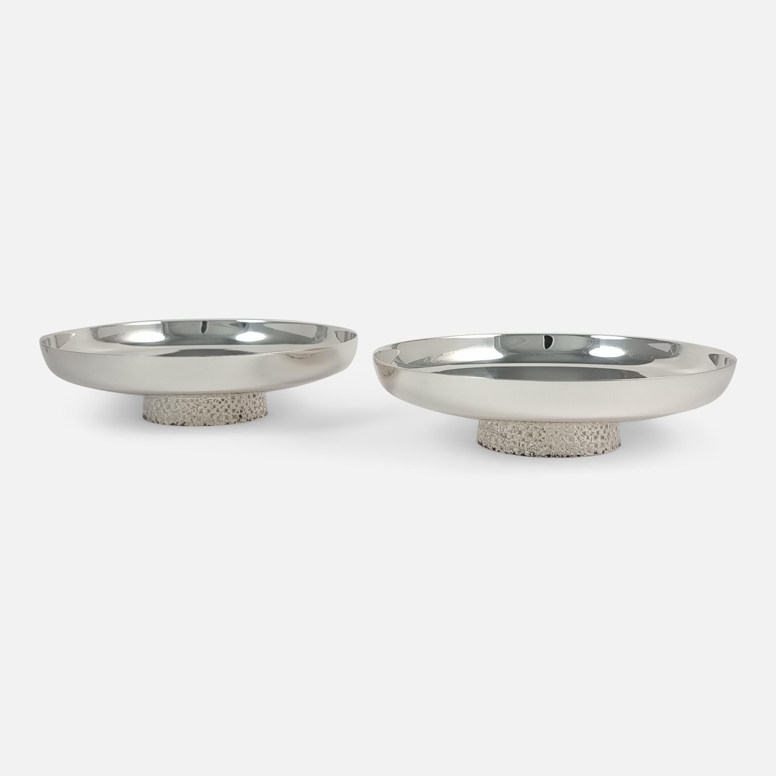 A pair of sterling silver dishes, made in 1975 by Christopher Nigel Lawrence, the much collected contemporary silversmith. The shallow dishes are of circular form, with textured bark effect foot.

Assay: - .925 sterling silver.

Date: -