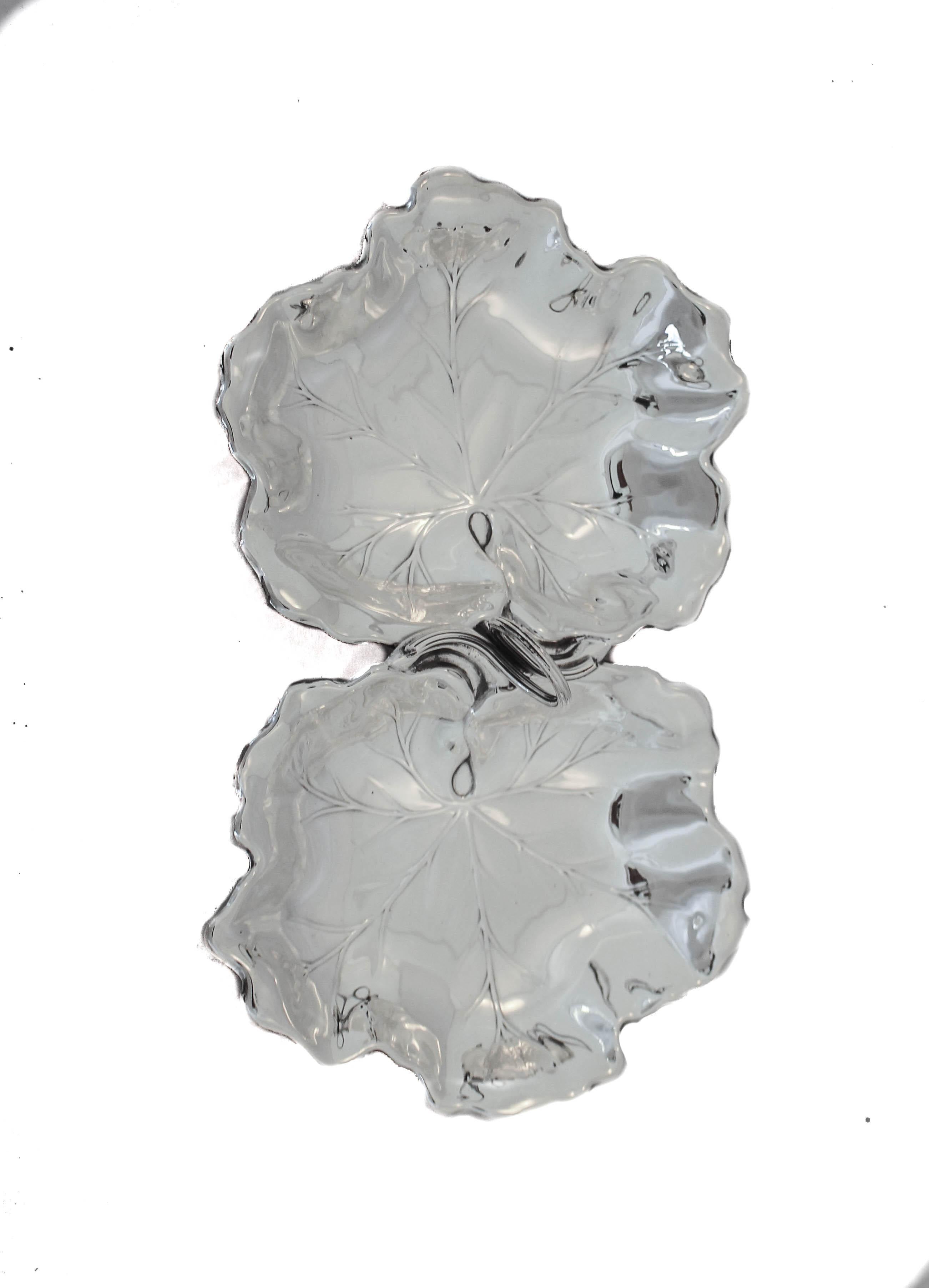 We are delighted to offer you this pair of sterling silver leaf dishes by Reed and Barton hall-marked 1952. They have scalloped edges and an etched pattern in the leaf mimicking a real leaf. In the center a handle allows for you to carry and pass